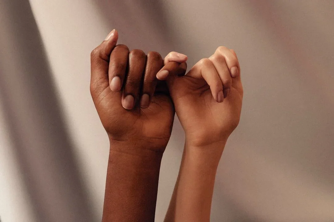 Two hands with interlocked pinky fingers