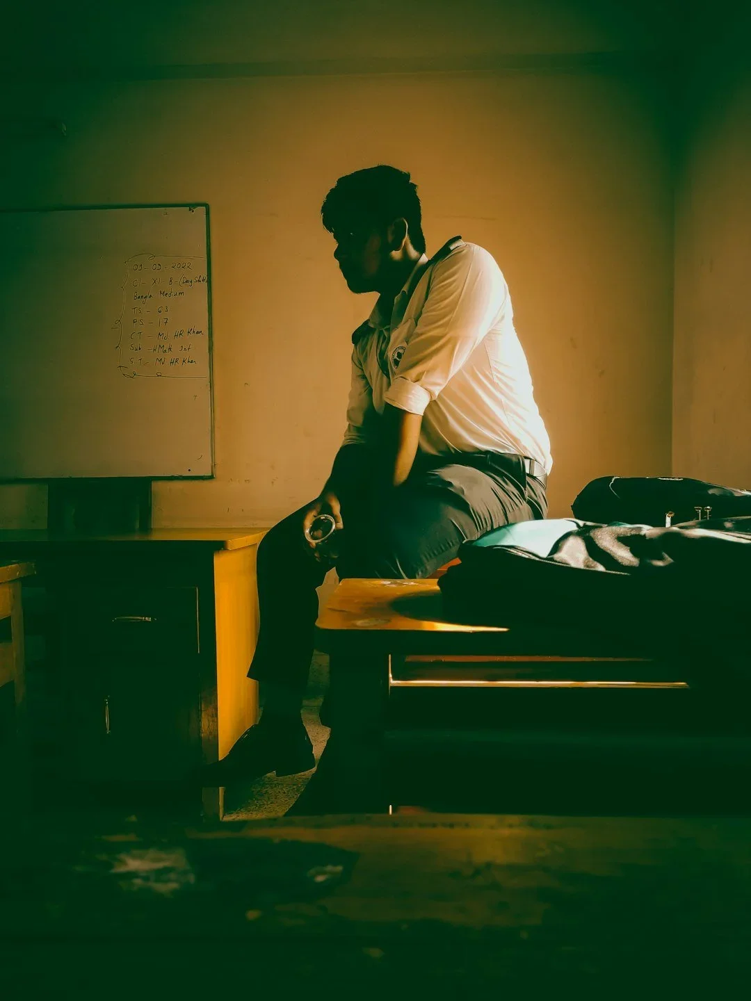 Man sitting in classroom looking forlorn