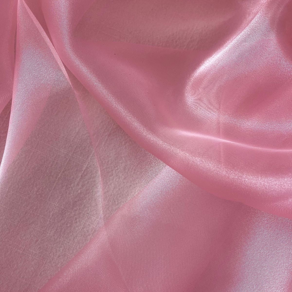 Close-up of pink satin fabric with smooth, shiny texture and gentle folds.