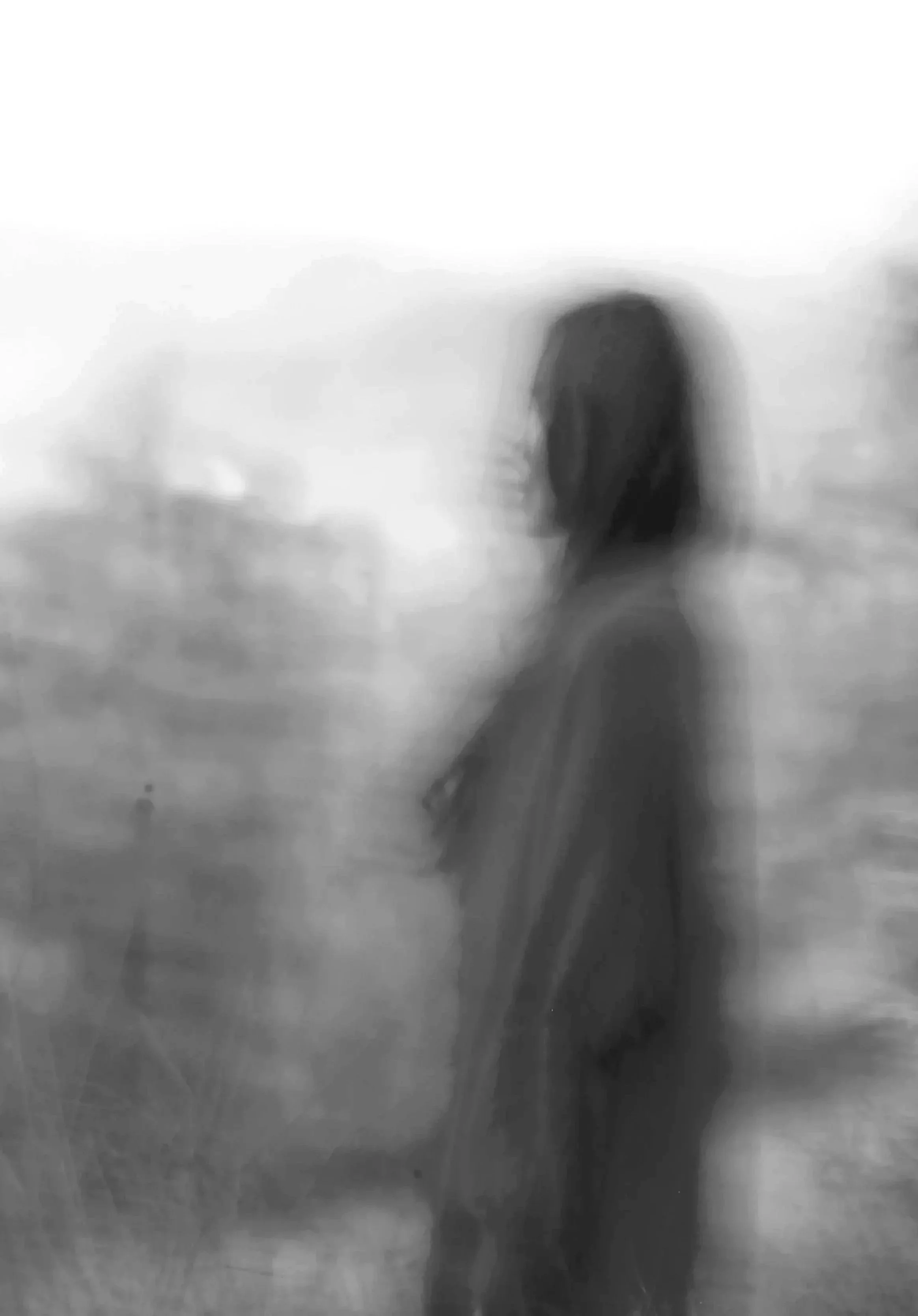 Silhouette floue d'une personne avec un casque, fond flou en noir et blanc.
