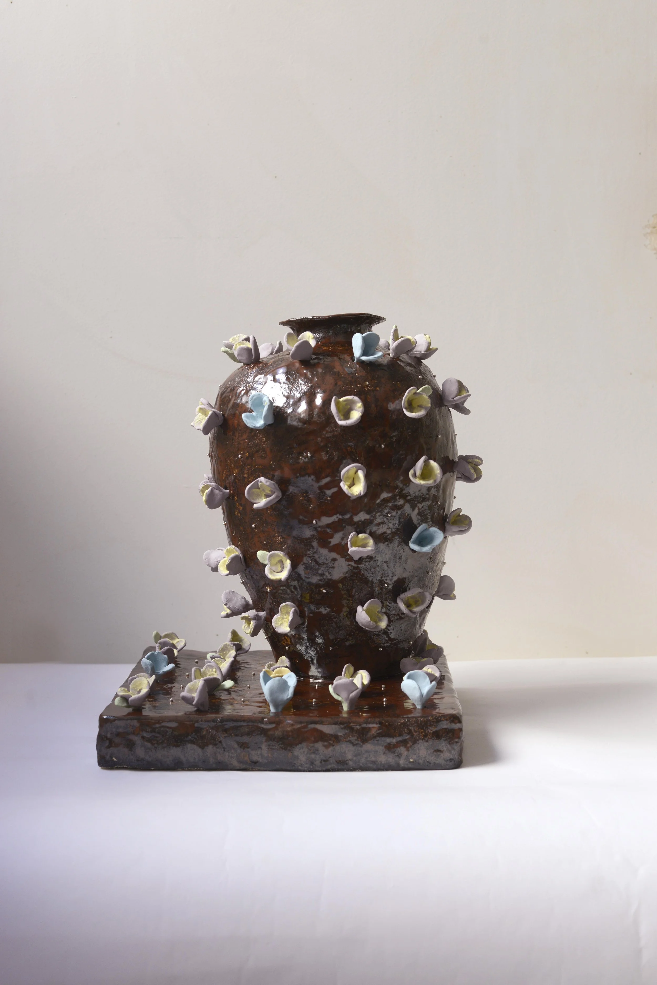 Vase en céramique en forme de bouquet avec décoration de petites fleurs en pastel.