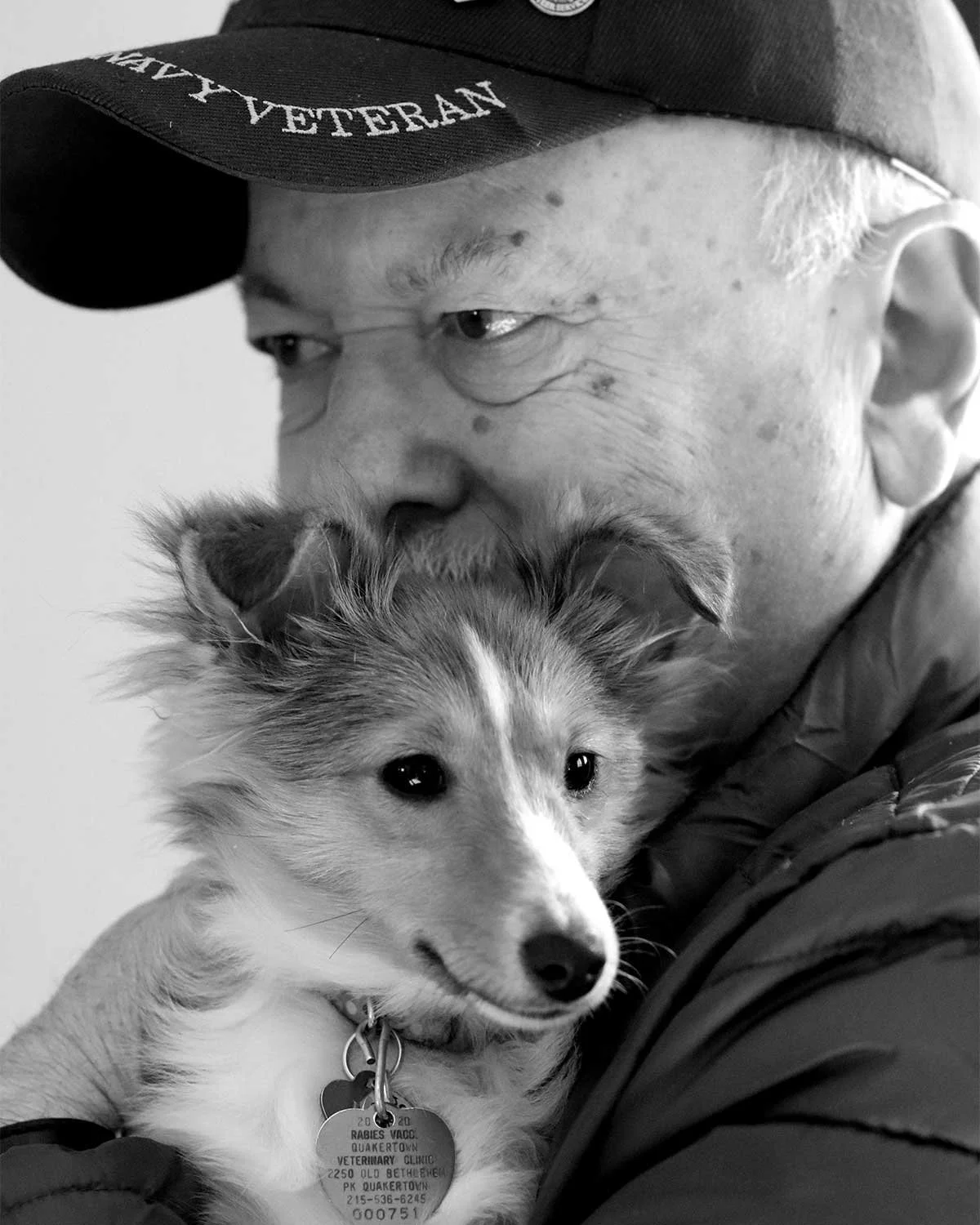 Military veteran holding a service dog close to his chest