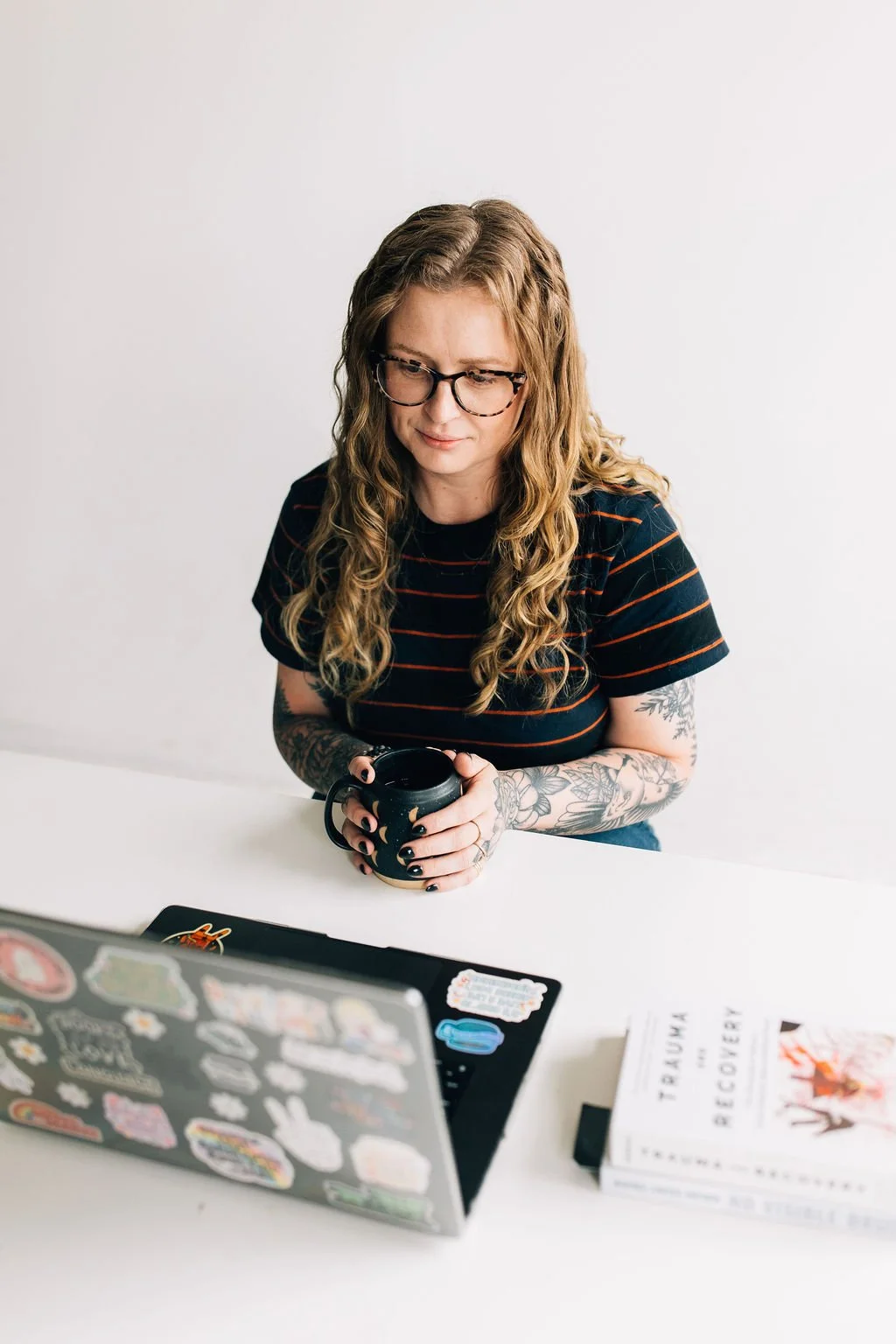Chaucee, a trauma therapist in Colorado, is sitting at a desk looking at her laptop while conducting a virtual mental health workshop
