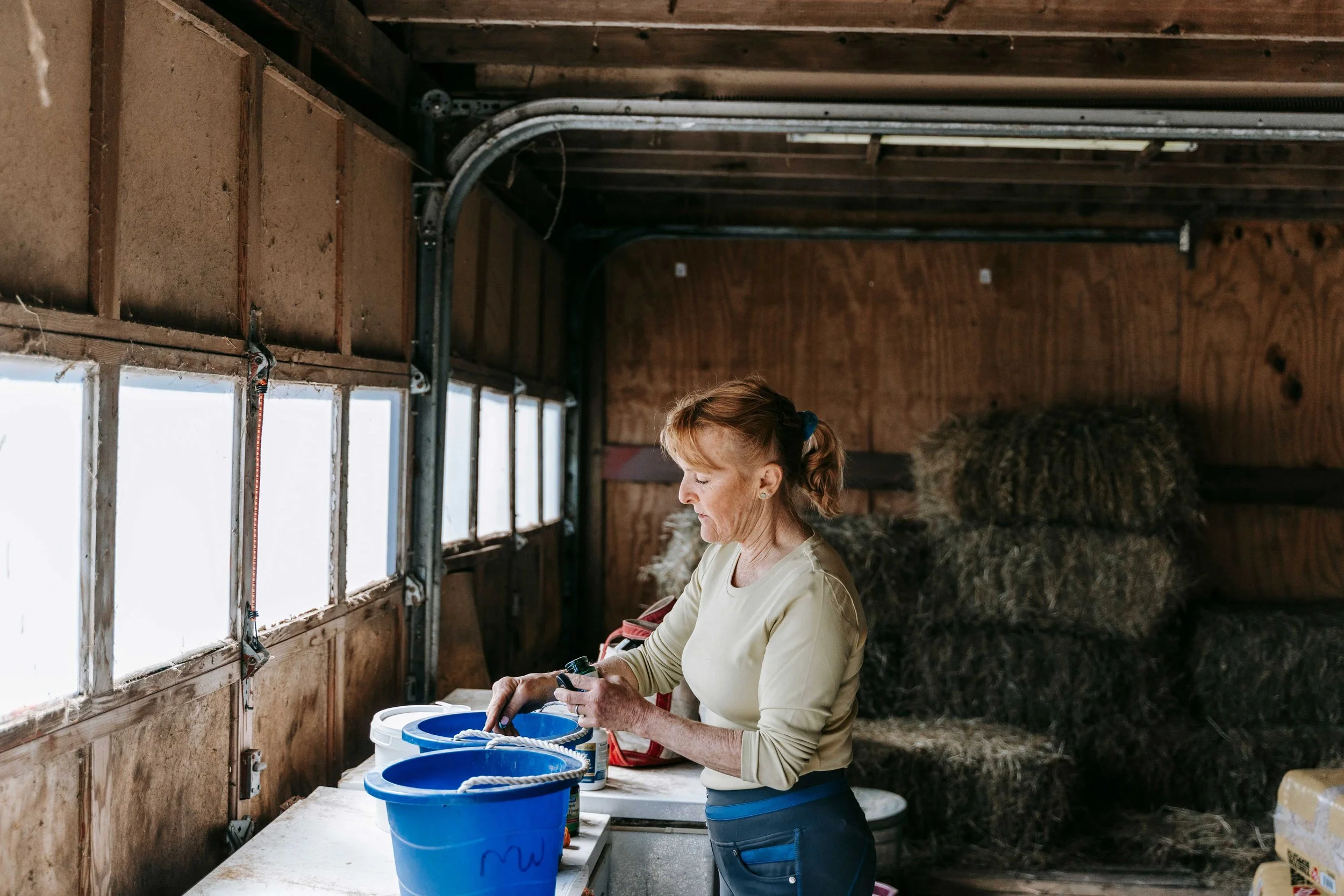 A woman preparing food for farm and ranch animals in the Colorado mountains inbetween online therapy appointments