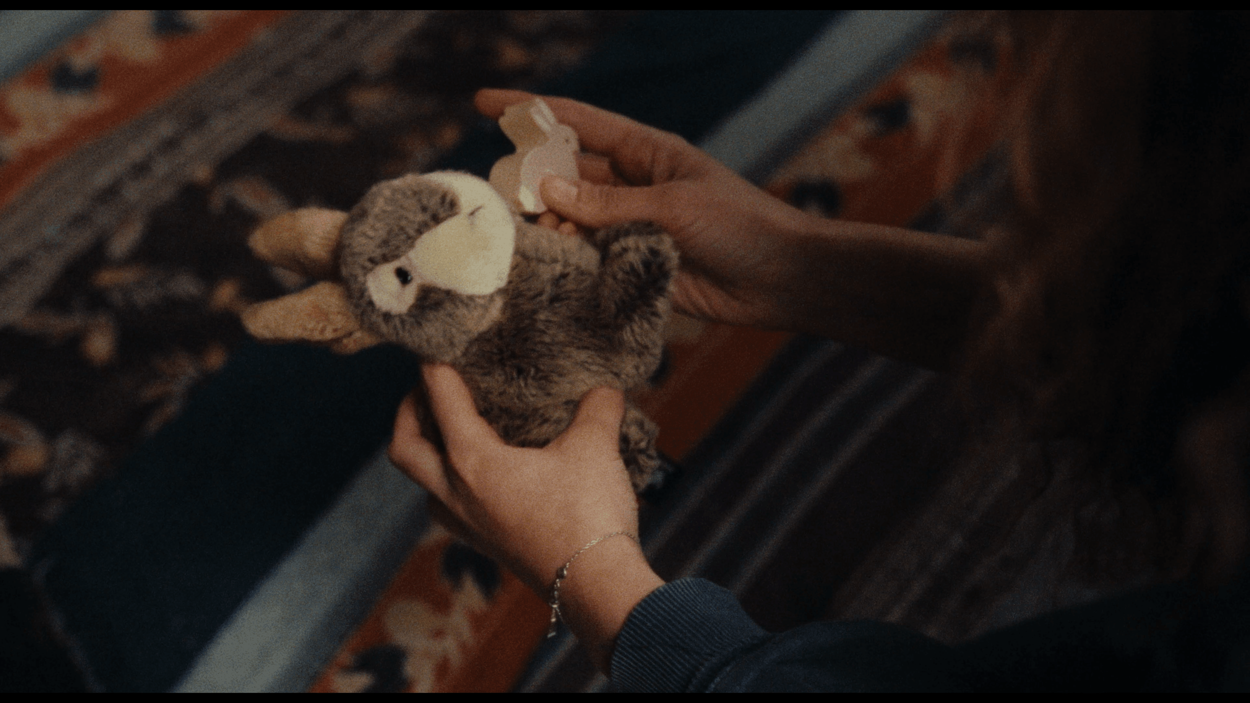 Person holding a plush bunny toy while small paper bunny cutout is being placed on it.