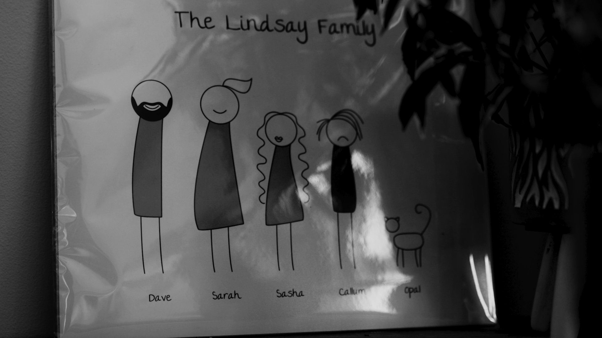 Drawing of a family called 'The Lindsay Family' with five figures labeled Dave, Sarah, Sasha, Callum, and Opal, each with distinct facial features and hairstyles, alongside a small dog.