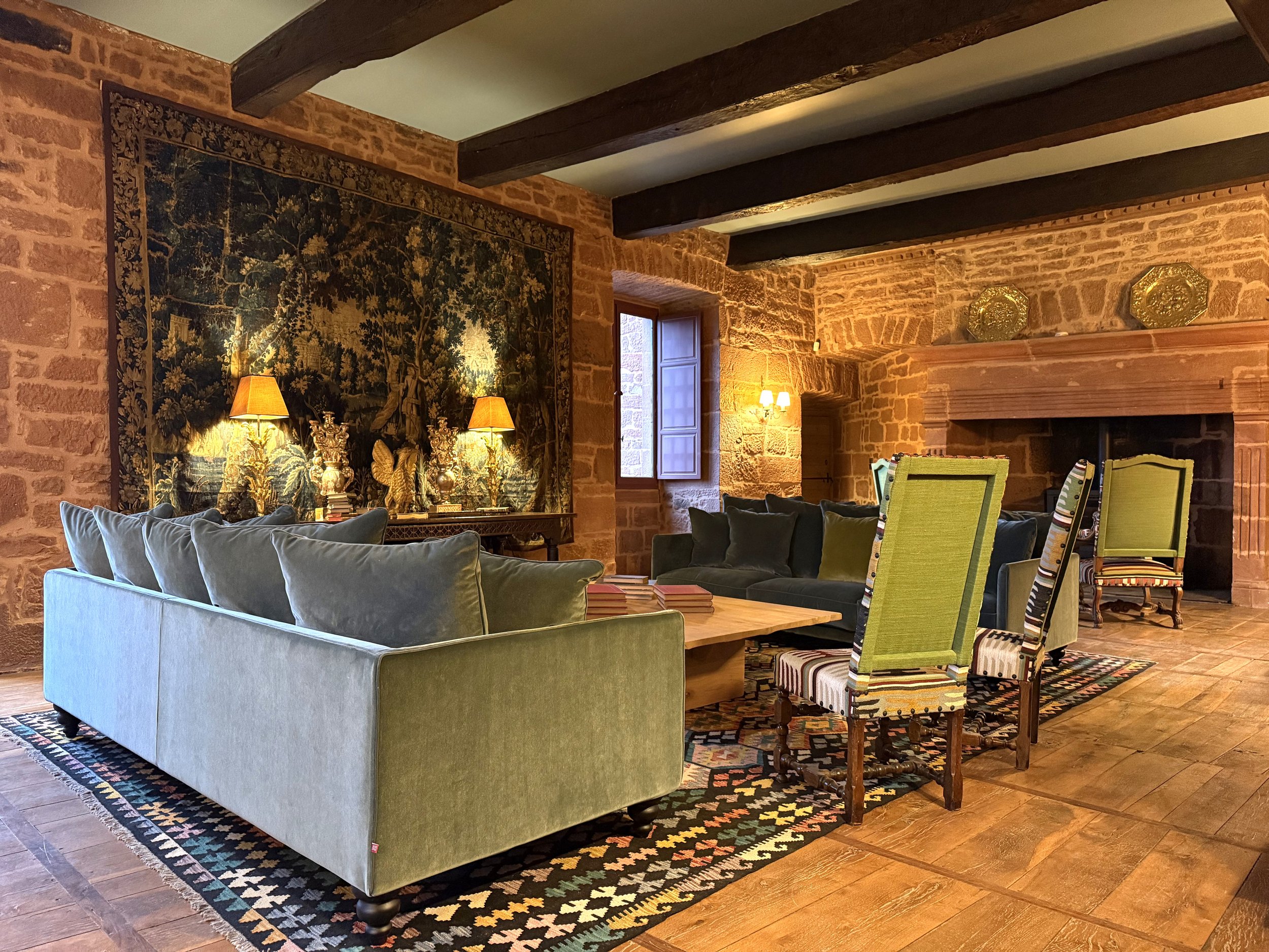 Salon d'hiver avec ses canapés, fauteuils et vue sur la cheminée et son pôele à bois
