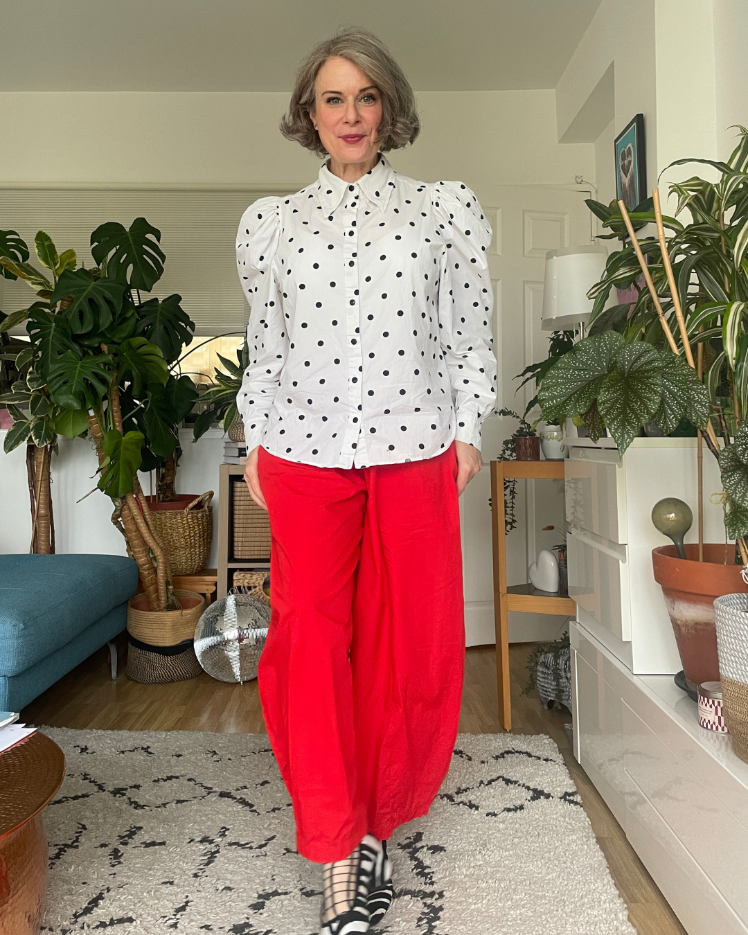 Fully stripped-back base outfit: white polka dot shirt and red wide-leg trousers with zebra print shoes.