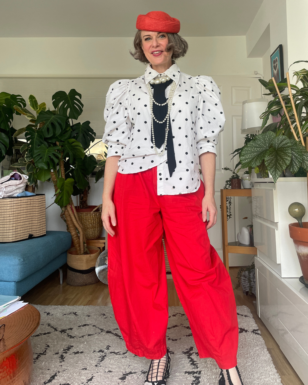 Base layer with a step-in accessory: black tie added to white polka dot shirt with pearls, red beret and red trousers.