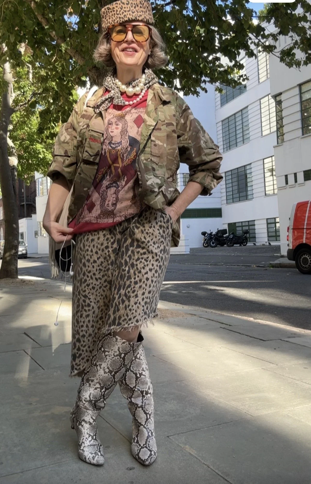 woman over 40 wearing a 3 pattern mix outfit shows snakeskin, camo and leopard all worn together