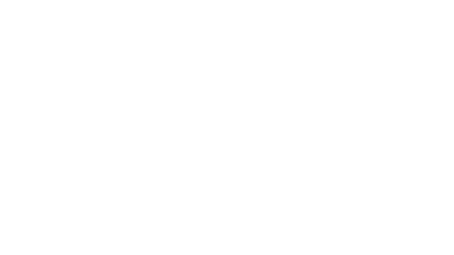 A black silhouette of a man standing with a hat on, holding a guitar, against a plain white background.