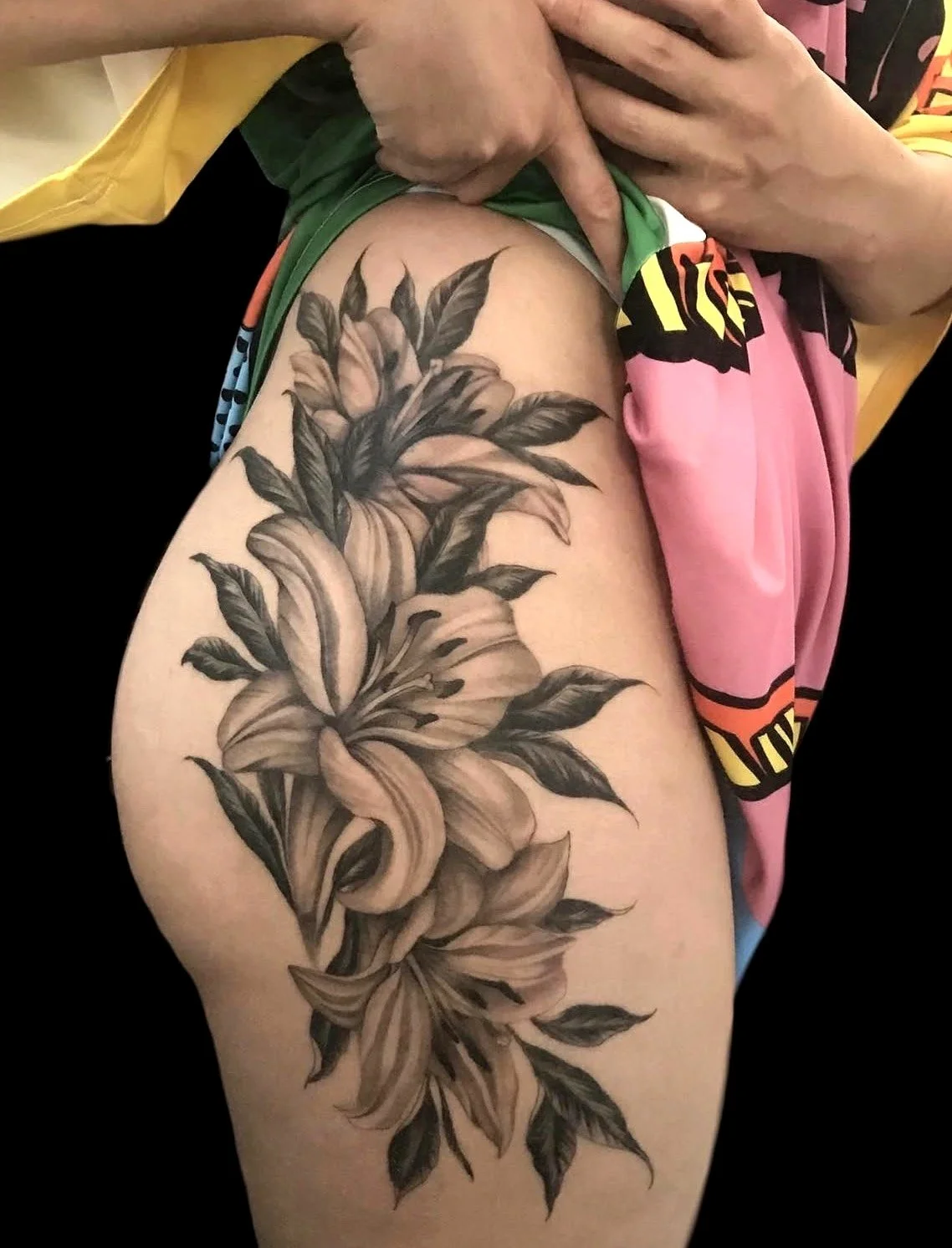 lilies tattooed on the leg black and grey flowers realistic