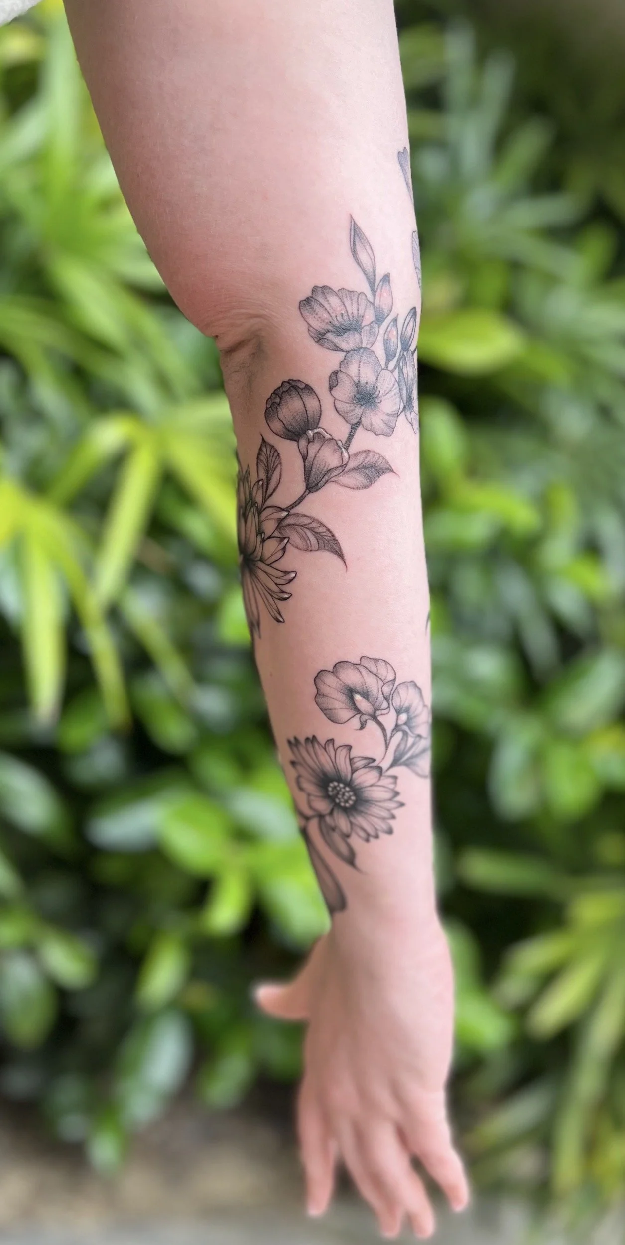 Sun flowers black and grey tattooed on the forearm by Telley