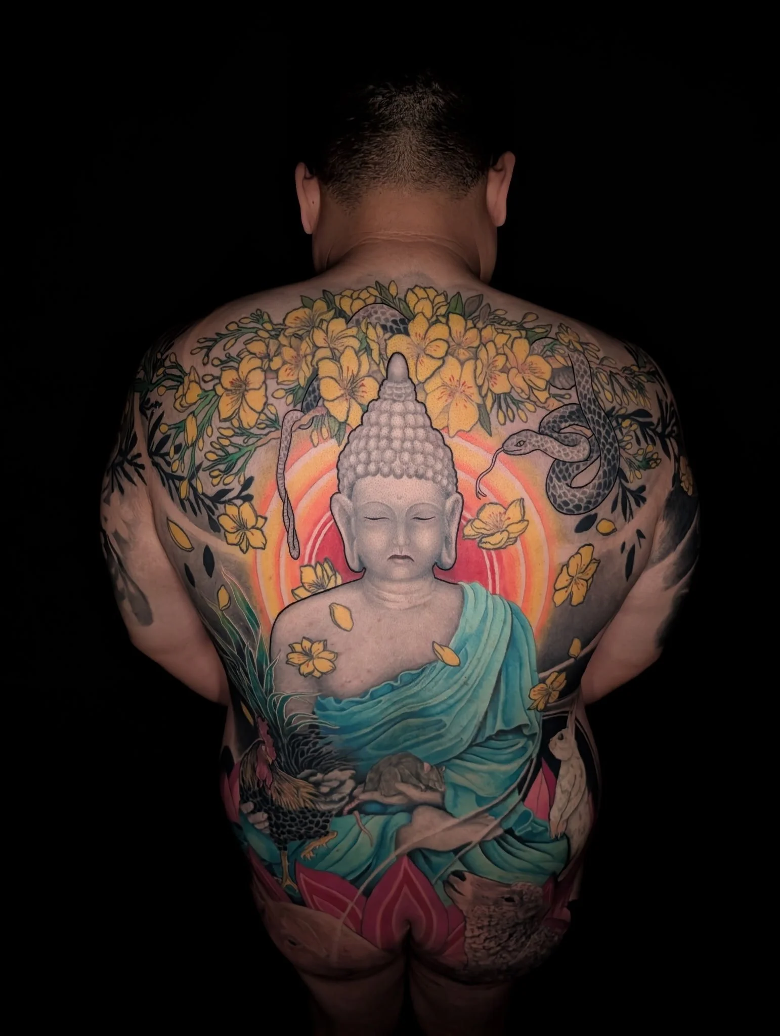 Japanese buddha back piece with yellow flowers tattoo by Zach Yokoyama