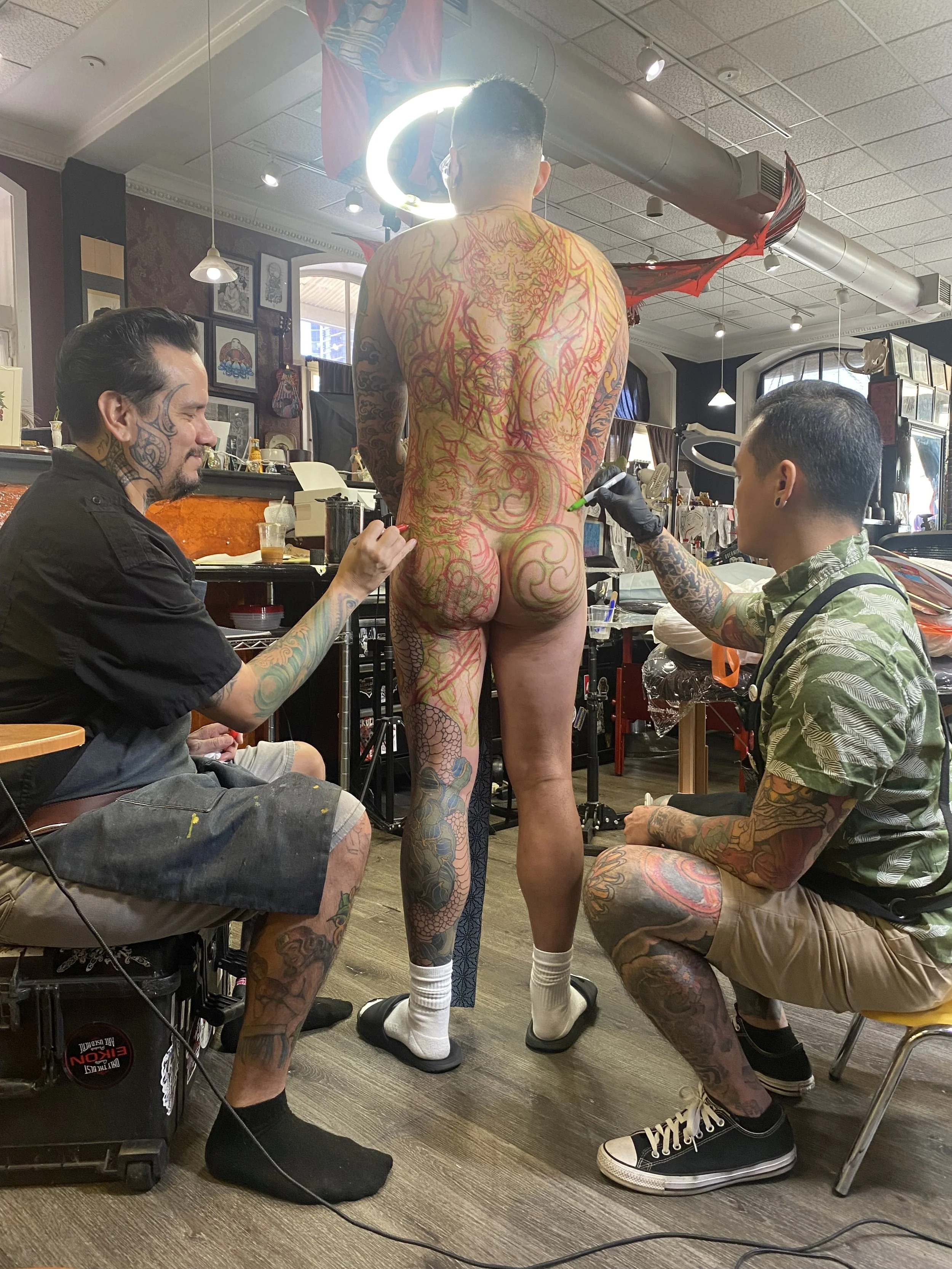 Richie Lucero and Zach Yokoyama collaborating on a large Japanese back piece tattoo at Black Cat Tattoo