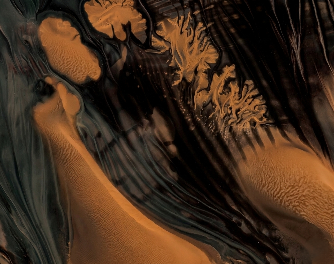 Abstract swirl of black and gold colors with textured, flowing patterns.