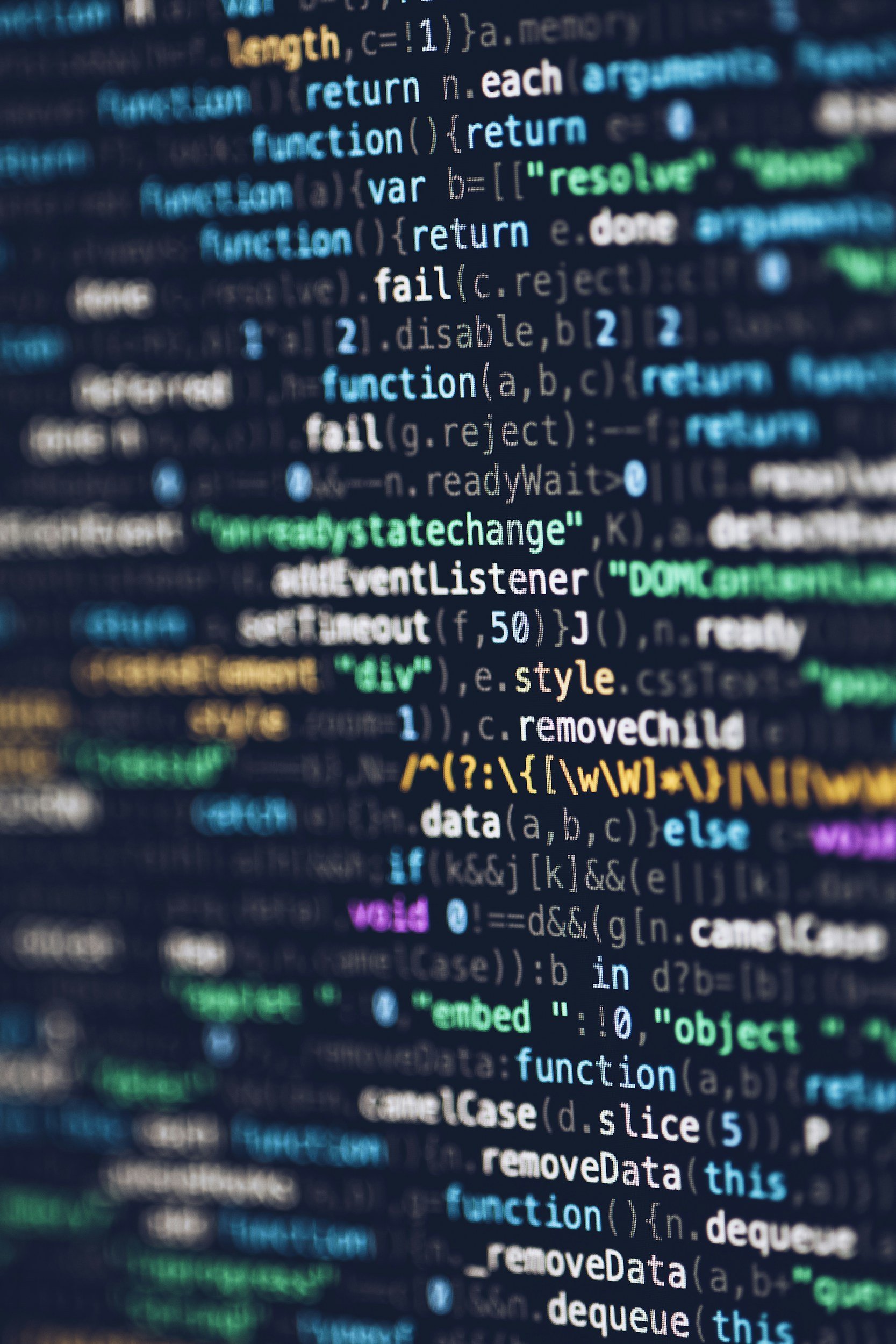 Close-up of computer code displayed on a screen with colorful syntax highlighting, predominantly in blue, green, yellow, and purple.