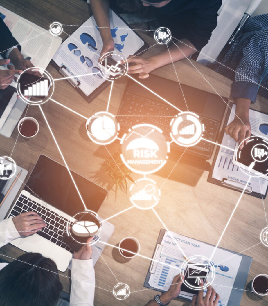 People working at a conference table over documents and laptops with digital graphics overlay showing risk management and data analysis icons.