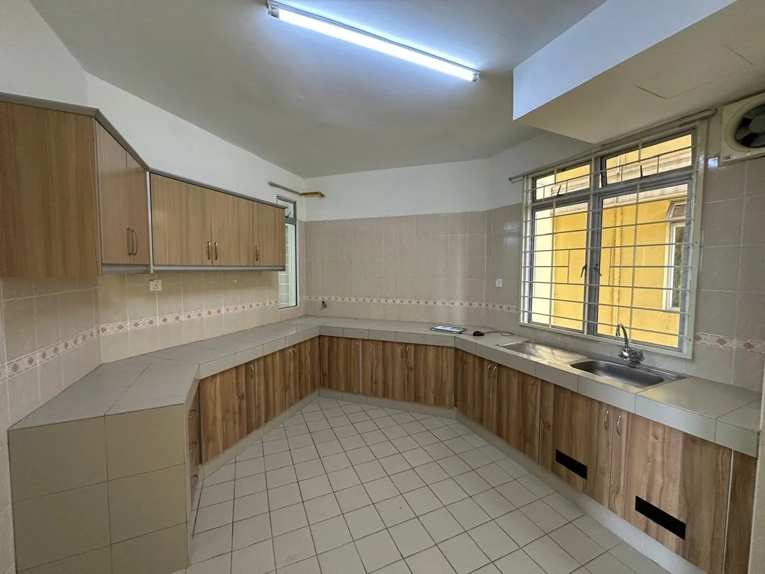 Empty kitchen with wooden cabinets, tiled countertops, and large window with metal bars.
