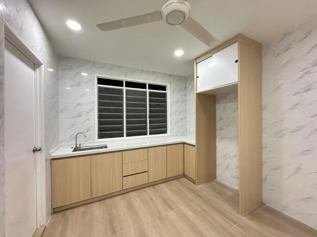 A modern kitchen with wooden cabinets, a single sink, marble-patterned walls, a large window with horizontal bars, and a ceiling fan with three blades.