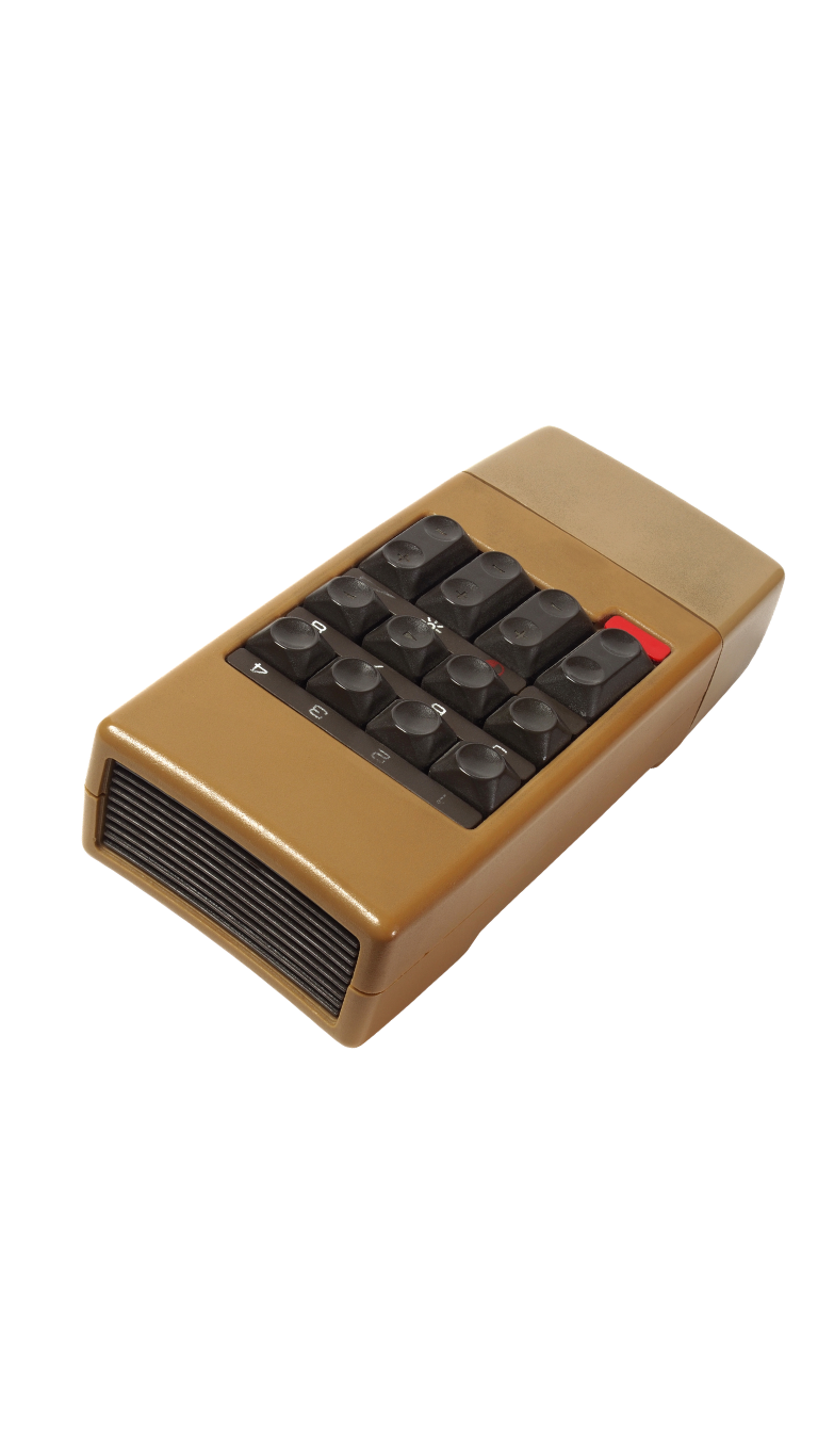 A vintage beige calculator with black buttons and a small red button on the top right.