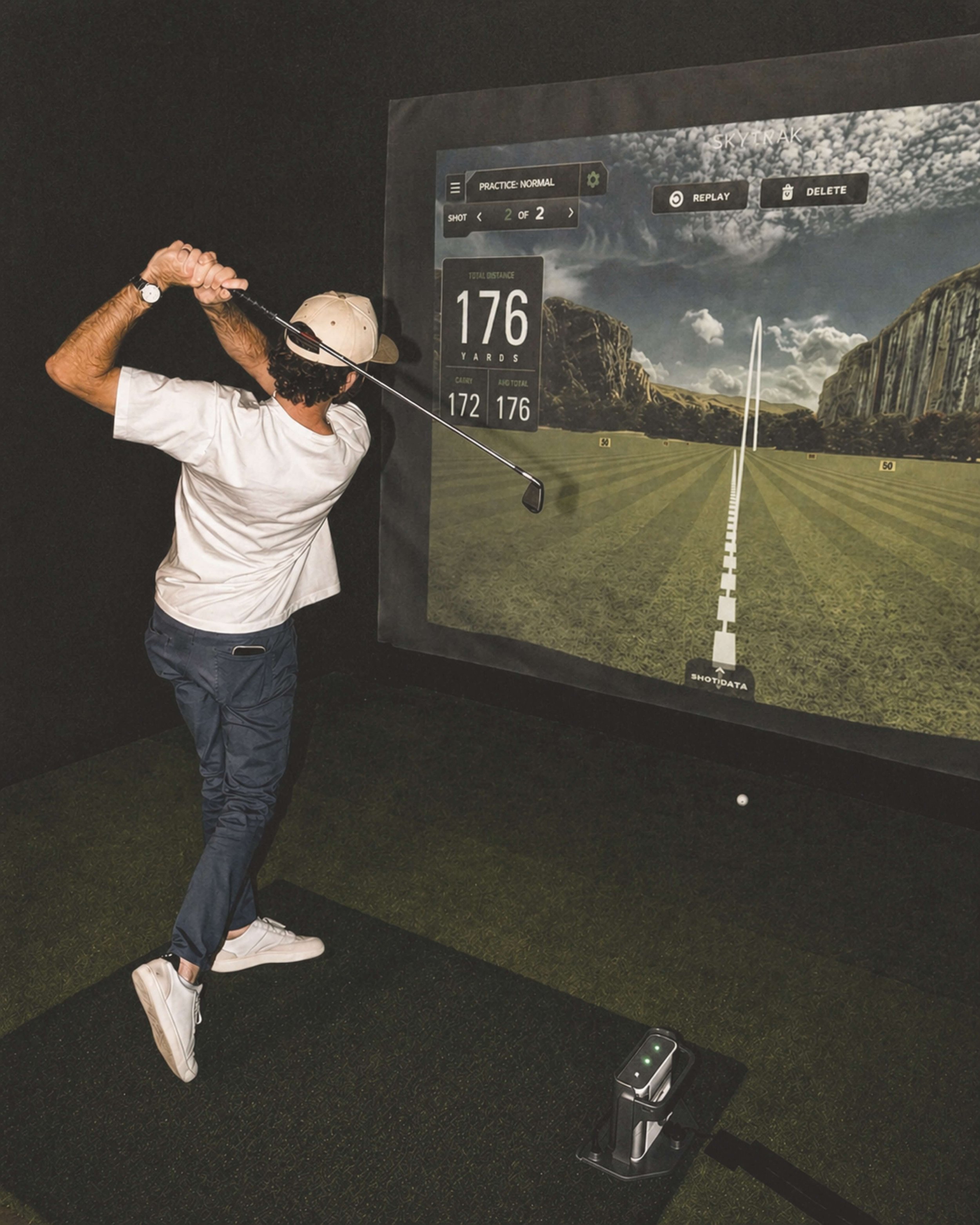 Guest taking a swing at a Lemont Golf simulator activation, shot distance displayed at 176 yards