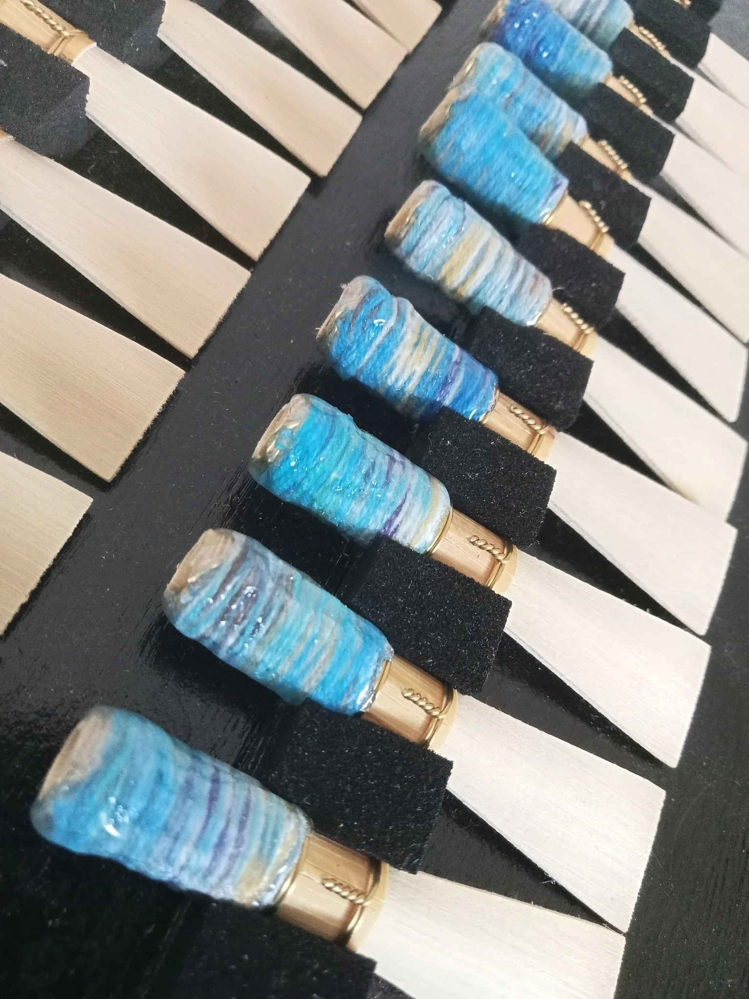 Close-up of piano keys with a set of colorful, marbled keycaps placed on some of the black keys.