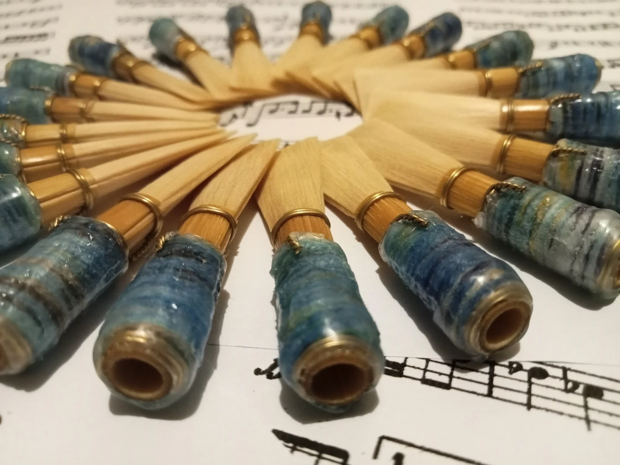 A circular arrangement of used fountain pen nibs placed on sheet music.