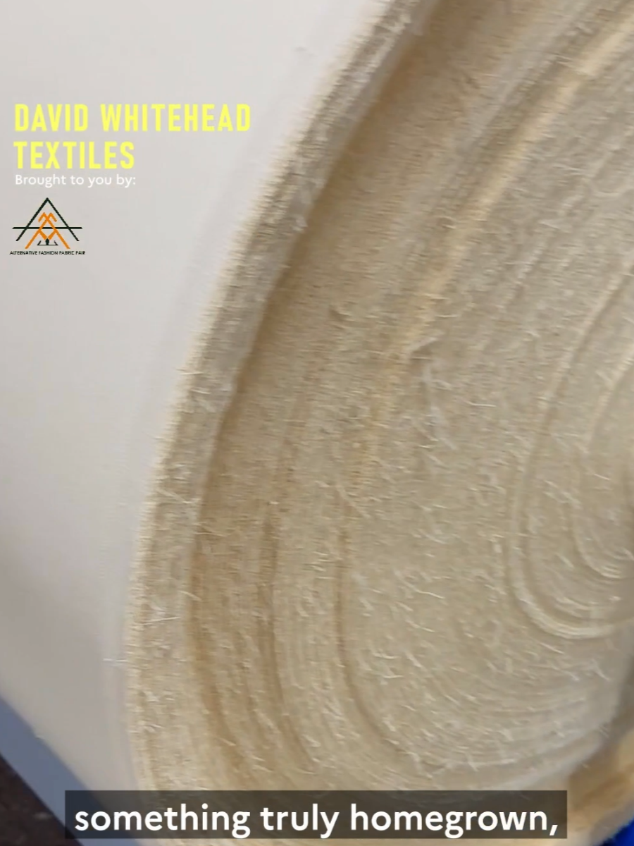Close-up of a roll of homegrown, natural, woven fabric or textile with a light beige color and visible fibers.