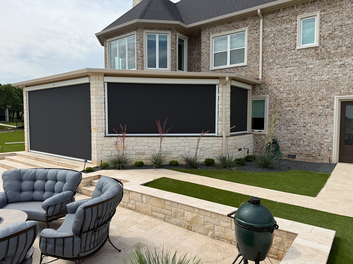 Backyard patio with outdoor lounge chairs, a grill, a tiled pathway, and a screened porch on a brick house.