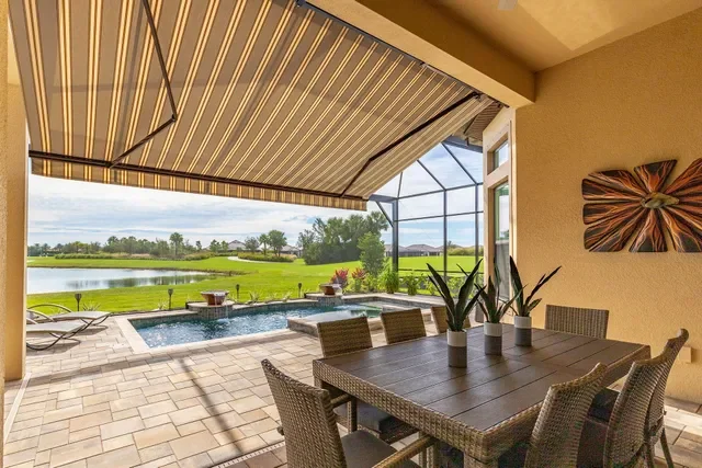 Covered patio overlooking a backyard with a swimming pool and a lawn beyond.
