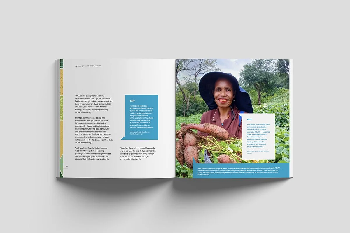 A woman smiling outdoors holding freshly harvested sweet potatoes in a garden with trees and greenery.