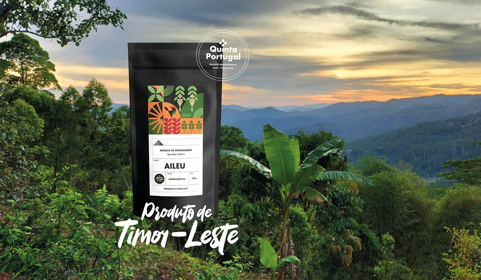 A package of Timor-Leste specialty Arabica coffee labeled 'AILEU' in front of a lush hillside landscape with green trees and a sunset sky.