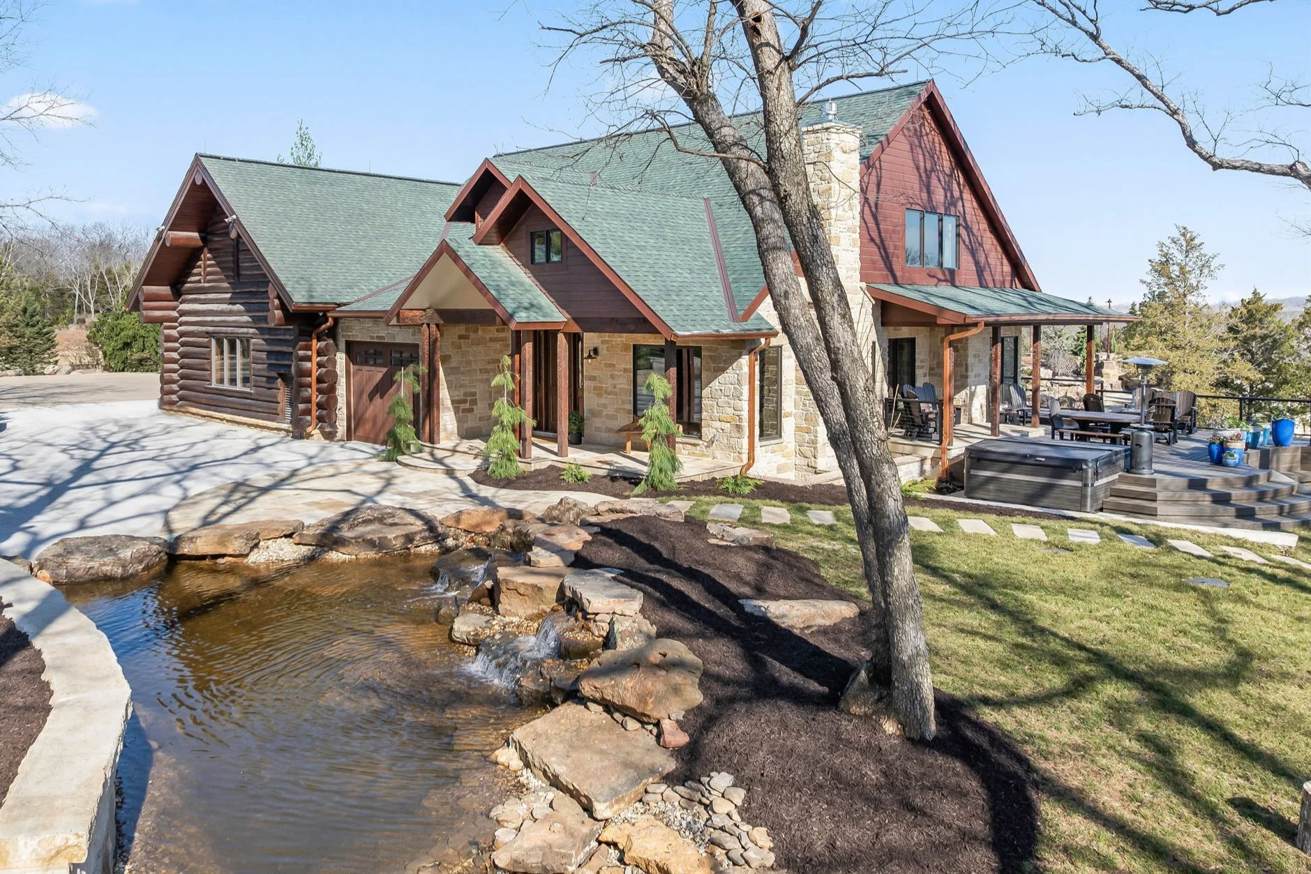 The Lookout Cottage exterior features a large front porch and deck, overlooking Kill Creek and a serene water feature.