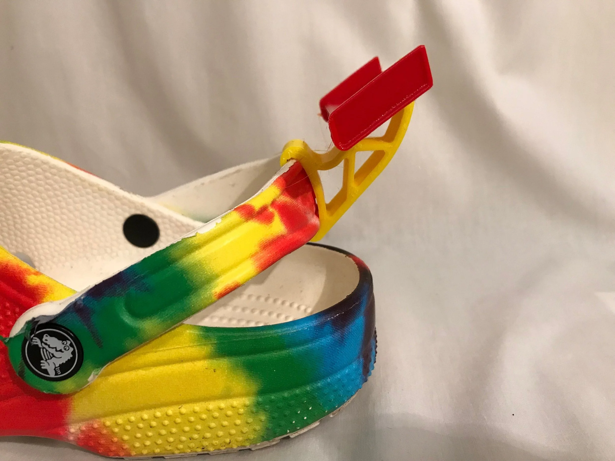 Red rear spoiler charm on a tie-dye Croc