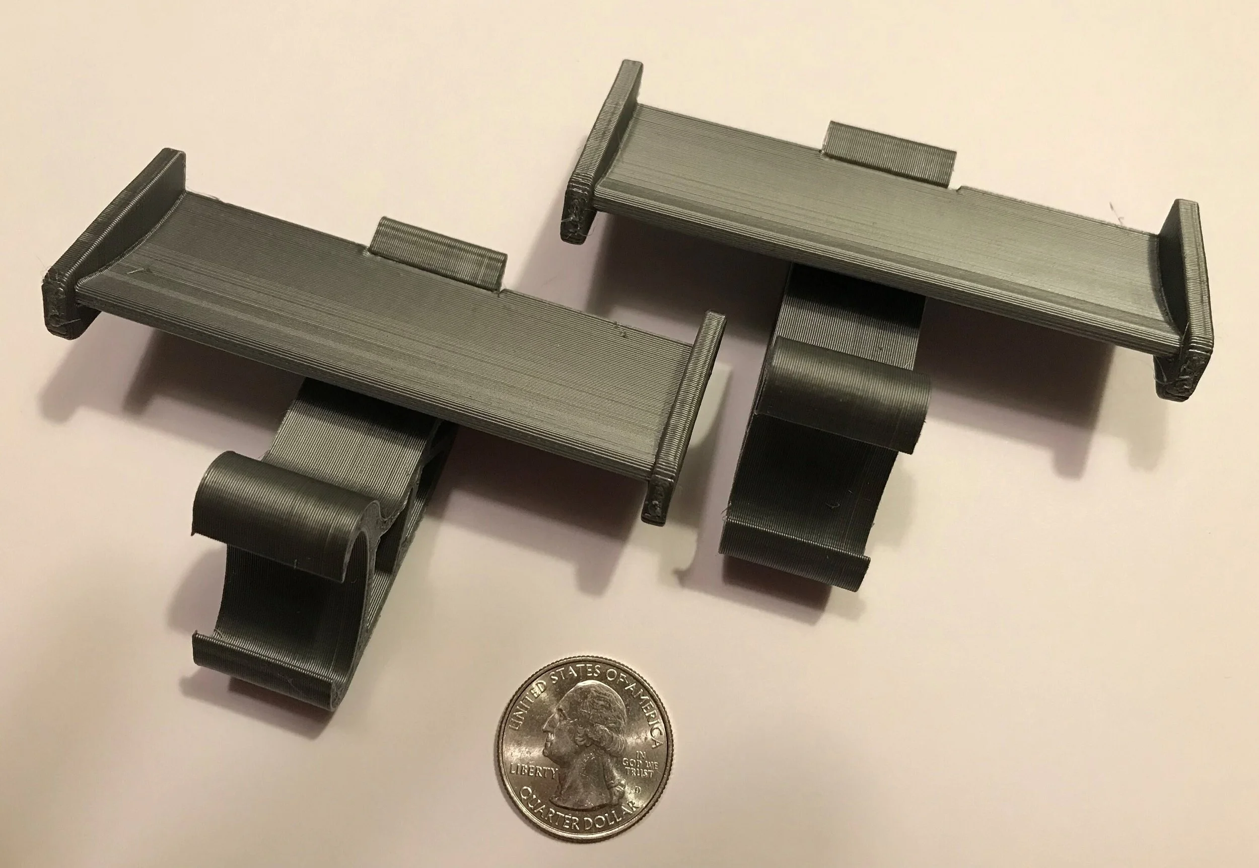 Pair of gray Croc spoilers next to a quarter for size