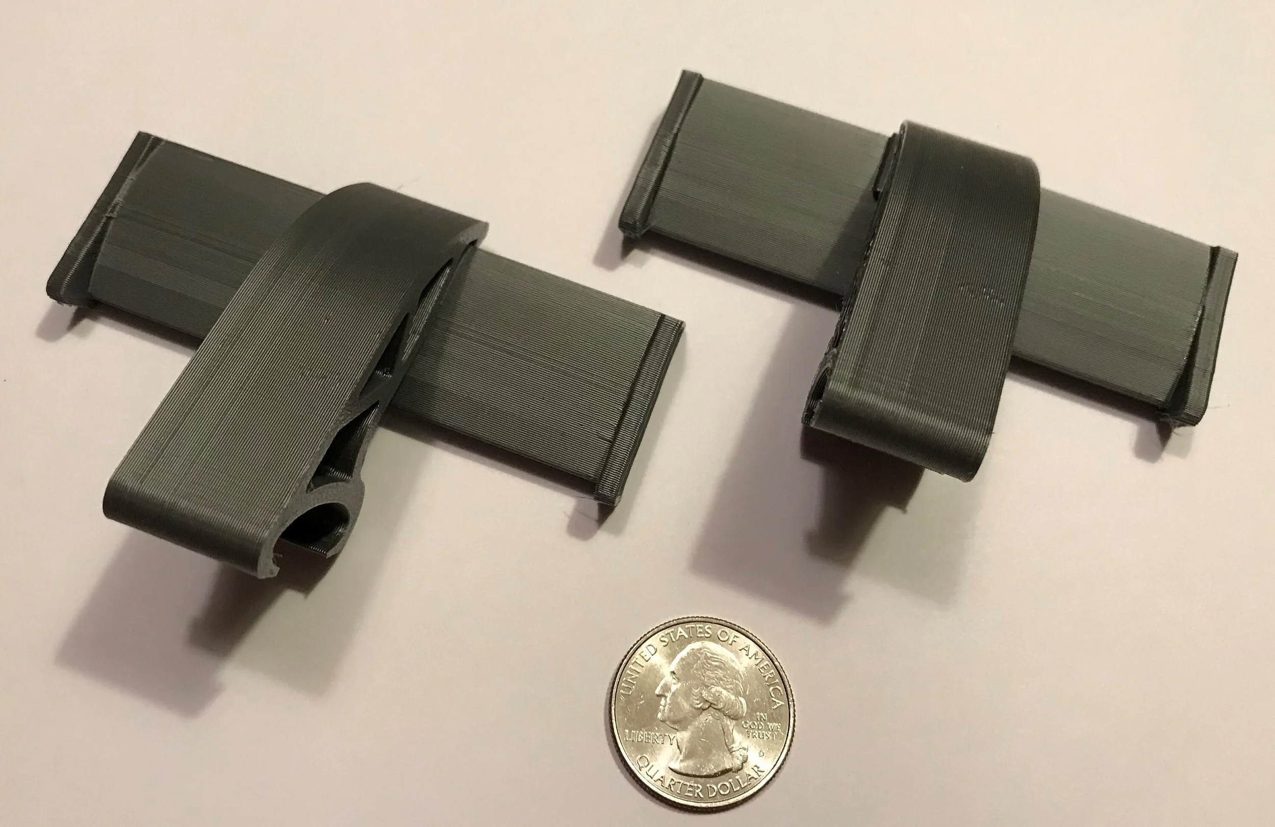 Pair of black Croc spoilers next to a quarter for size