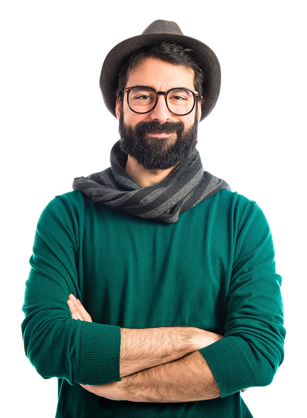 A man with a beard and glasses wearing a gray hat, scarf, and green sweater, with arms crossed, smiling in front of a black background.