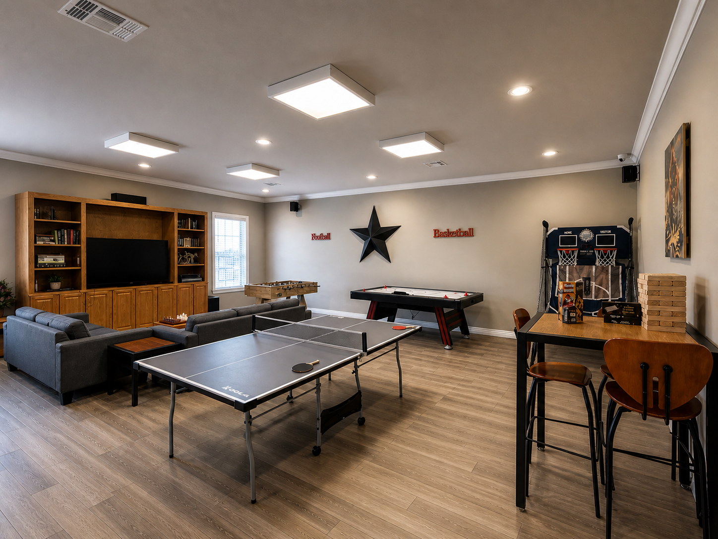 A recreation room with a ping pong table, air hockey, video game basketball machine, foosball table, and sofa seating.