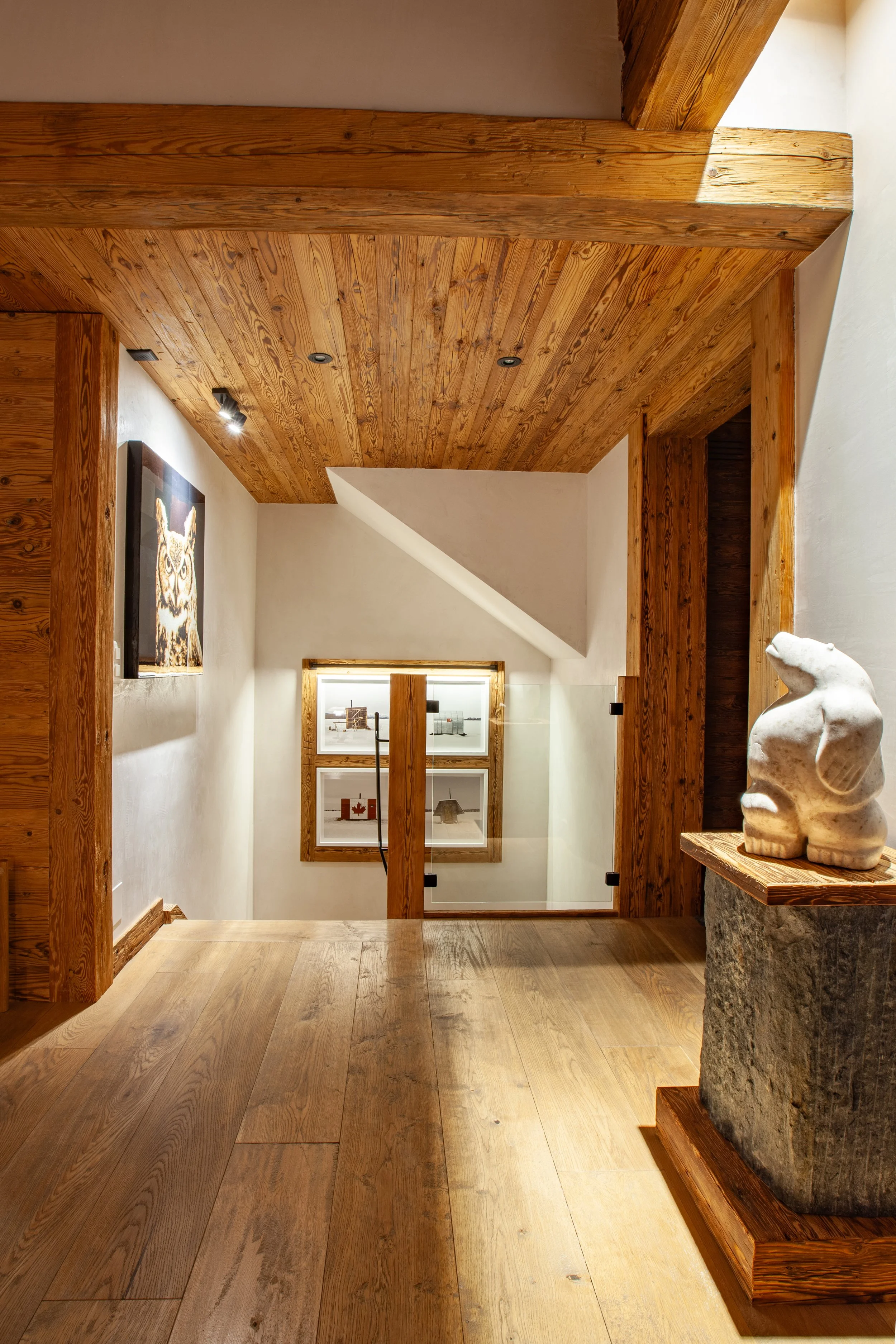 Inuit sculpture in foreground with contemporary art collection on staircase wall, Chalet la Vigne Verbier Switzerland