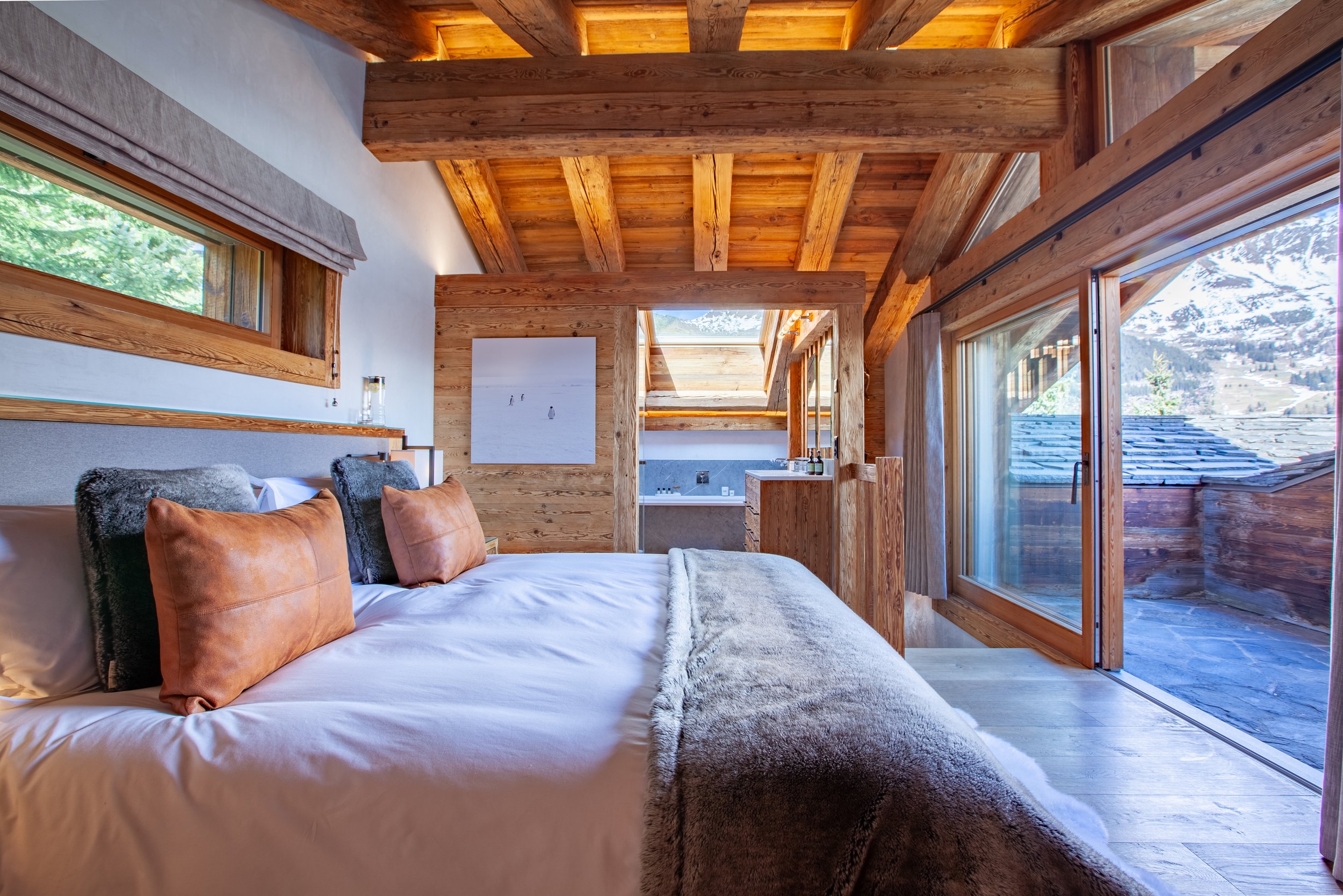 Luxury master bedroom suite with private balcony and panoramic mountain views, Chalet la Vigne Verbier Switzerland
