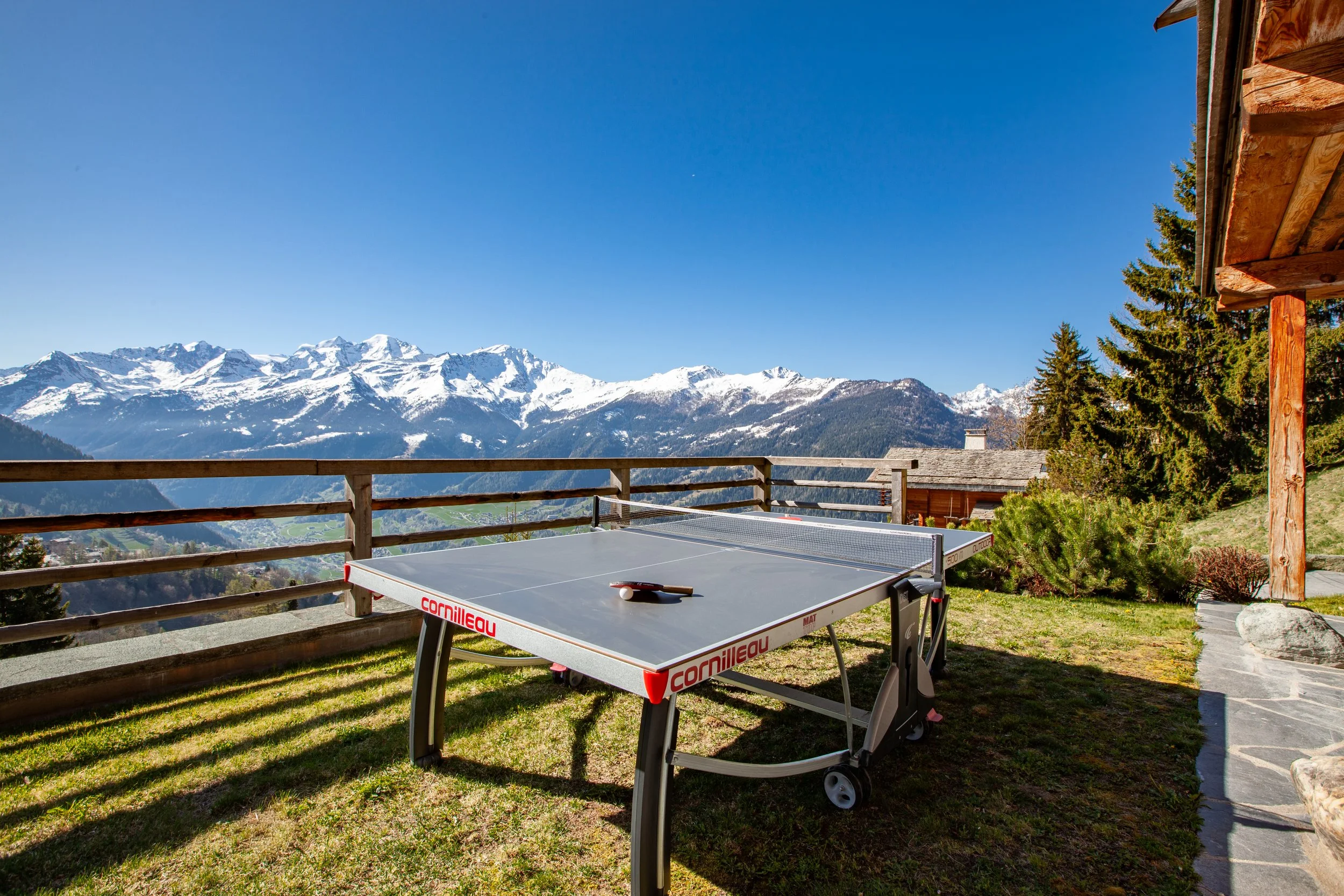 Table tennis on sunny terrace with panoramic Alpine mountain views, Chalet la Vigne Verbier luxury ski chalet Switzerland