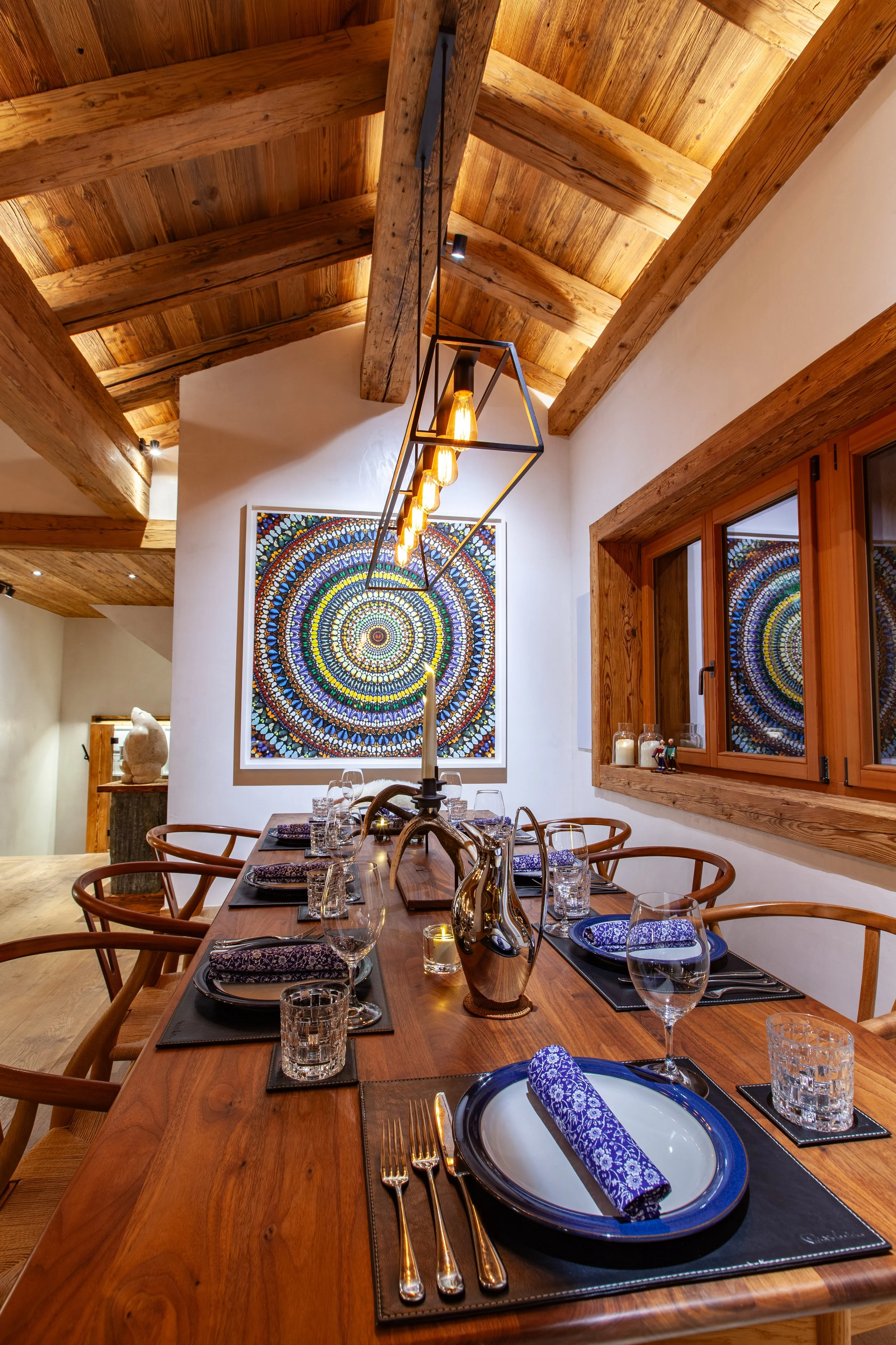 Dining table with striking contemporary artwork, Chalet la Vigne Verbier luxury ski chalet Switzerland
