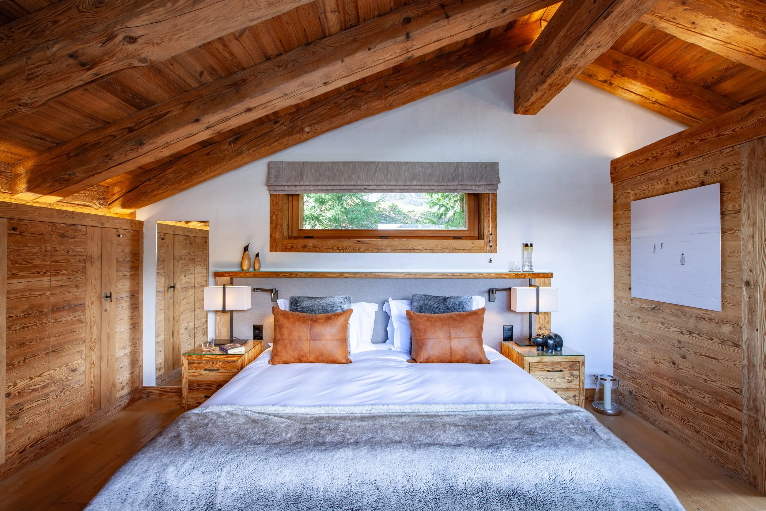 Luxury master bedroom with vaulted wooden ceiling, fur throws and mountain chalet character, Chalet la Vigne Verbier