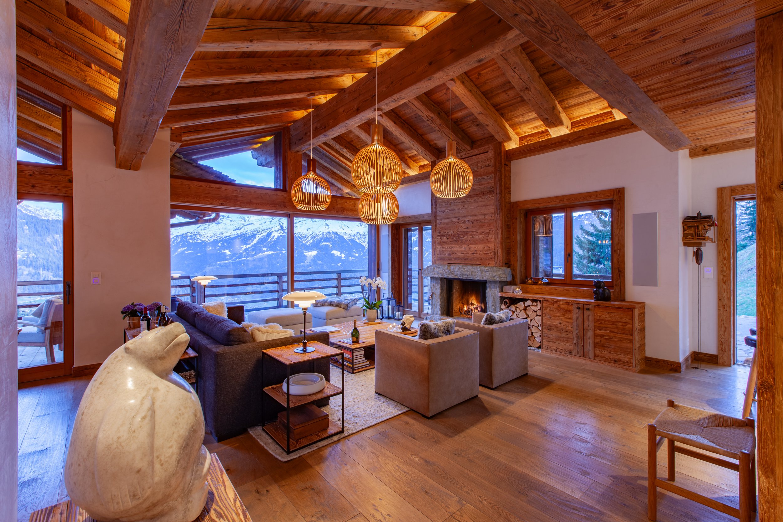 Luxury chalet living room at dusk with panoramic Alpine mountain views, Chalet la Vigne Verbier Switzerland