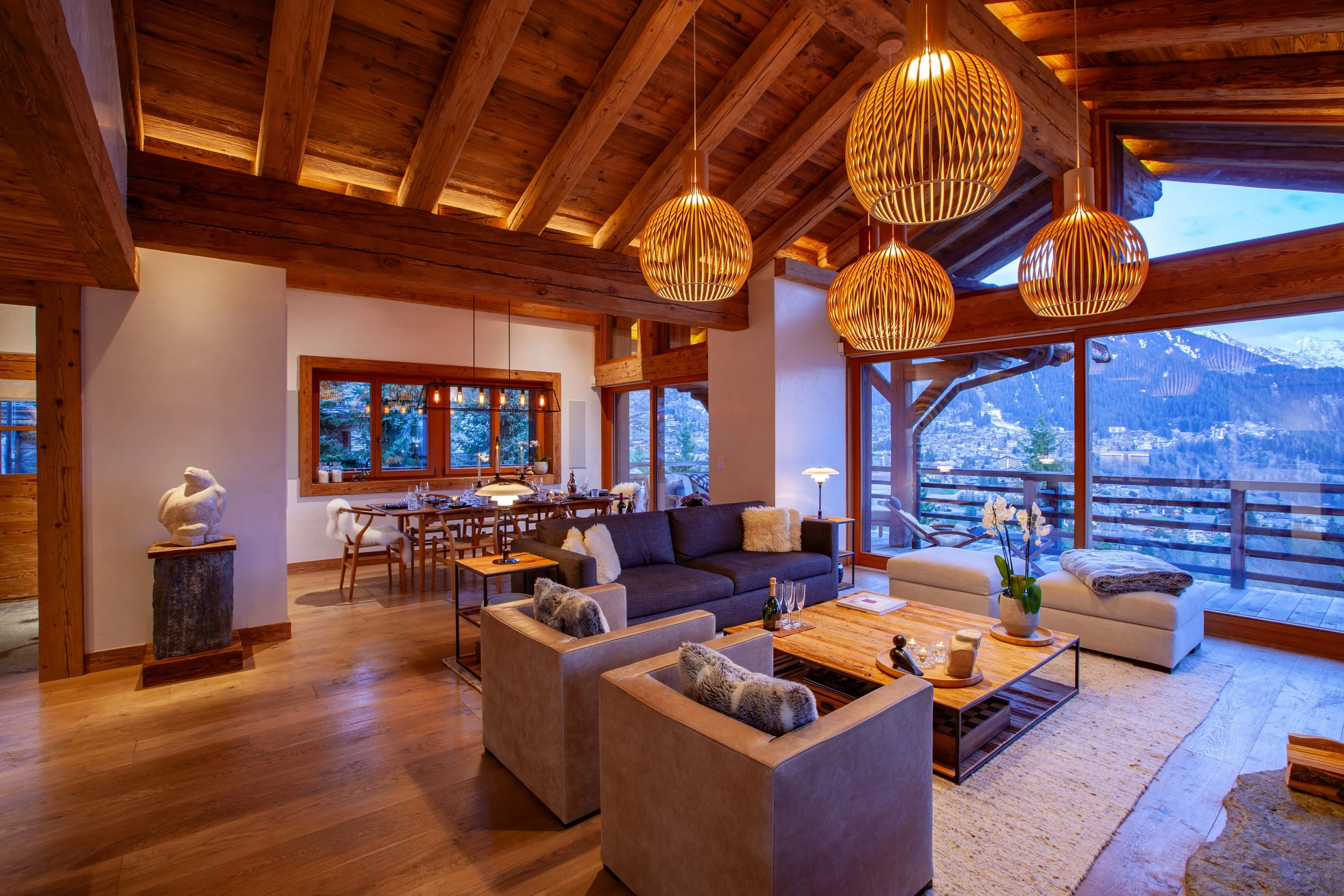 Living and dining area with Inuit bear sculpture, Secto Design and Louis Poulsen lighting, Meridiani furniture and panoramic Alpine views, Chalet la Vigne Verbier Switzerland