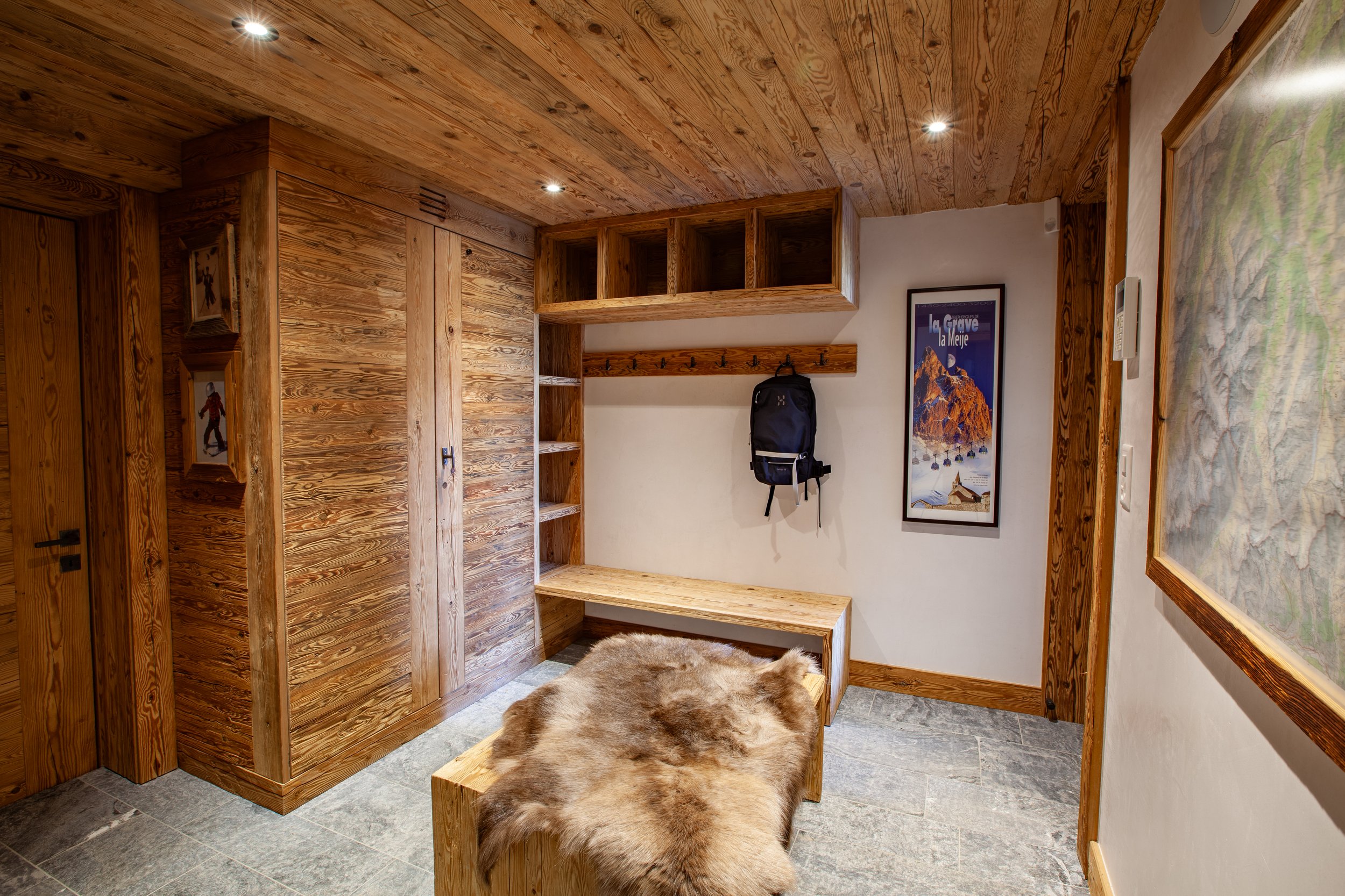 Ski room with traditional Swiss wooden interior, La Grave poster and Haglöfs backpack, Chalet la Vigne Verbier Switzerland