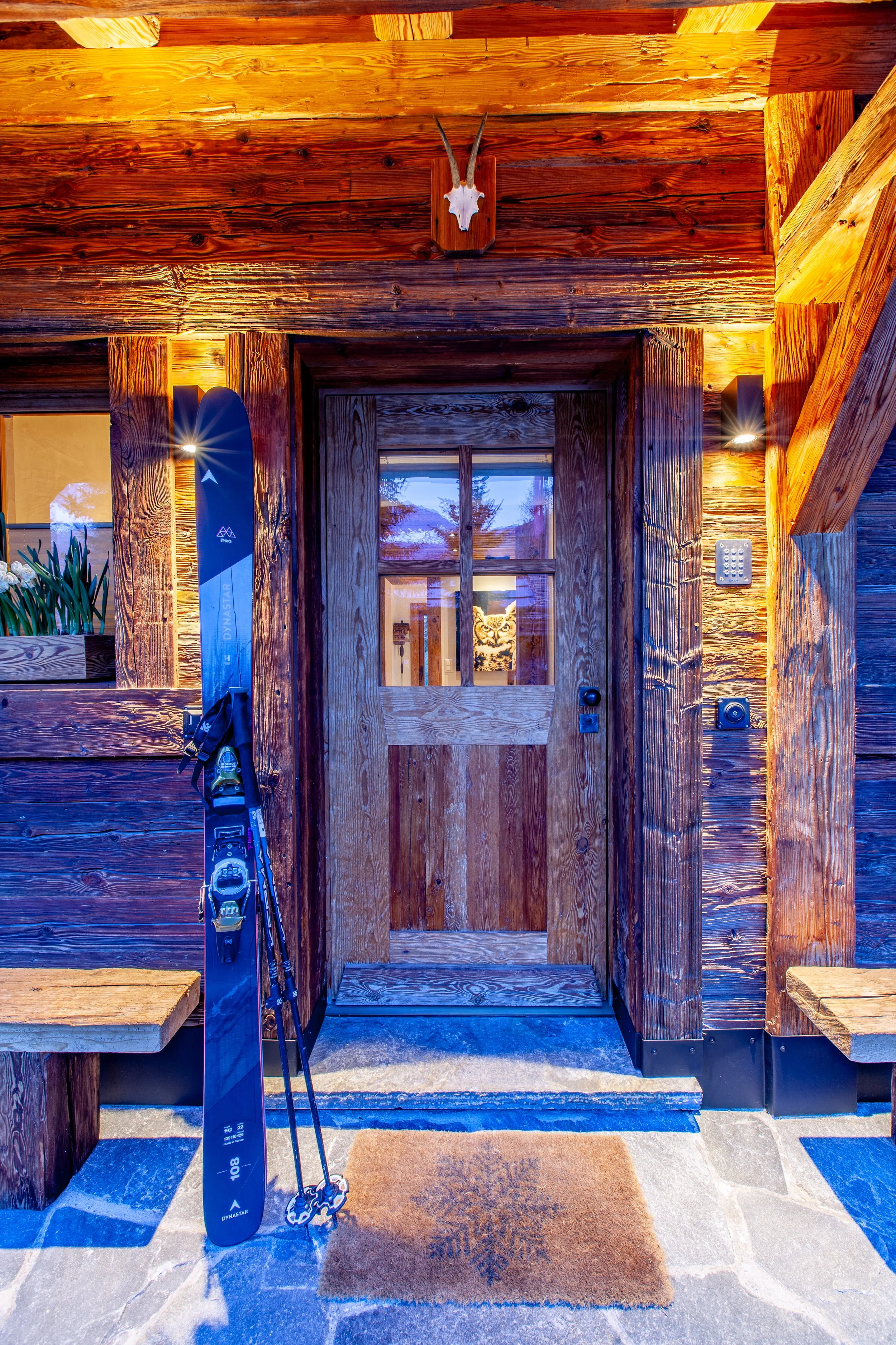 Chalet la Vigne Verbier front door at night with Dynastar M-Pro 108 skis, luxury ski chalet Switzerland