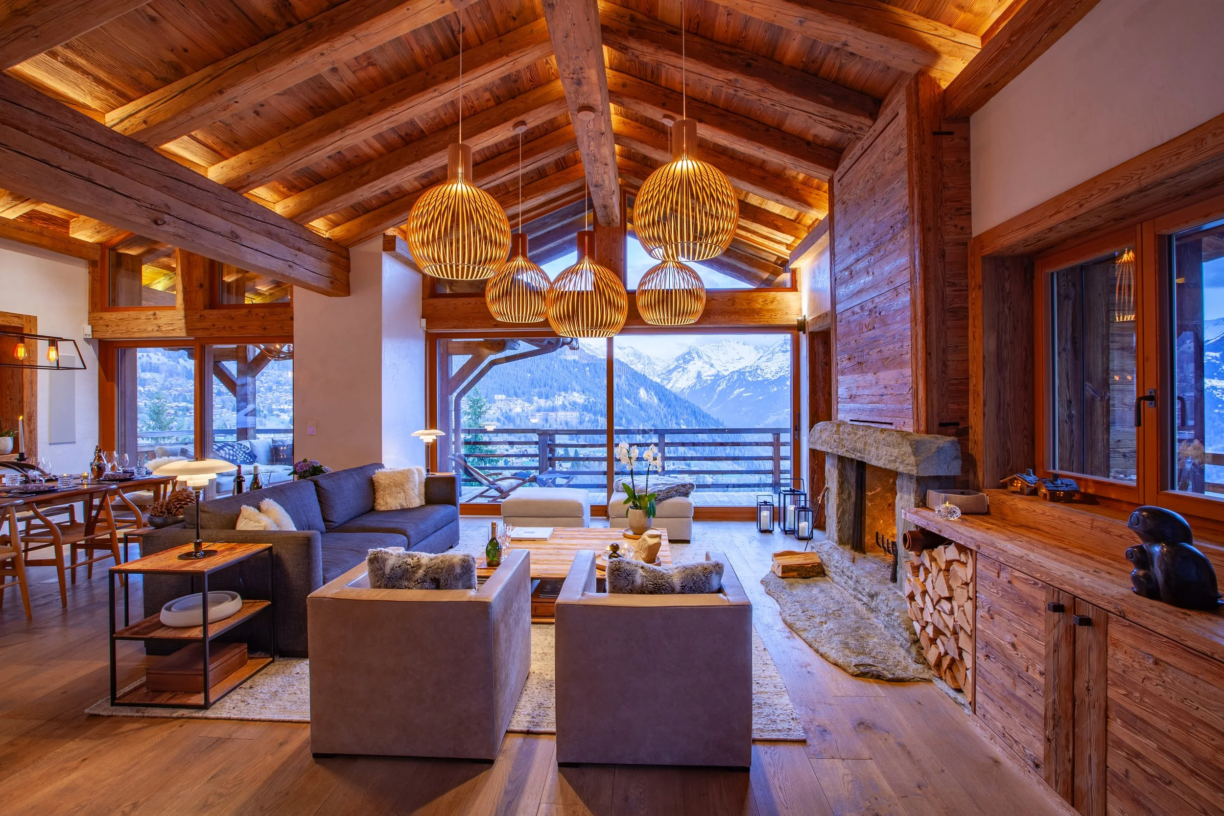 Luxury ski chalet living room at dusk with panoramic Alpine mountain views, Chalet la Vigne Verbier Switzerland