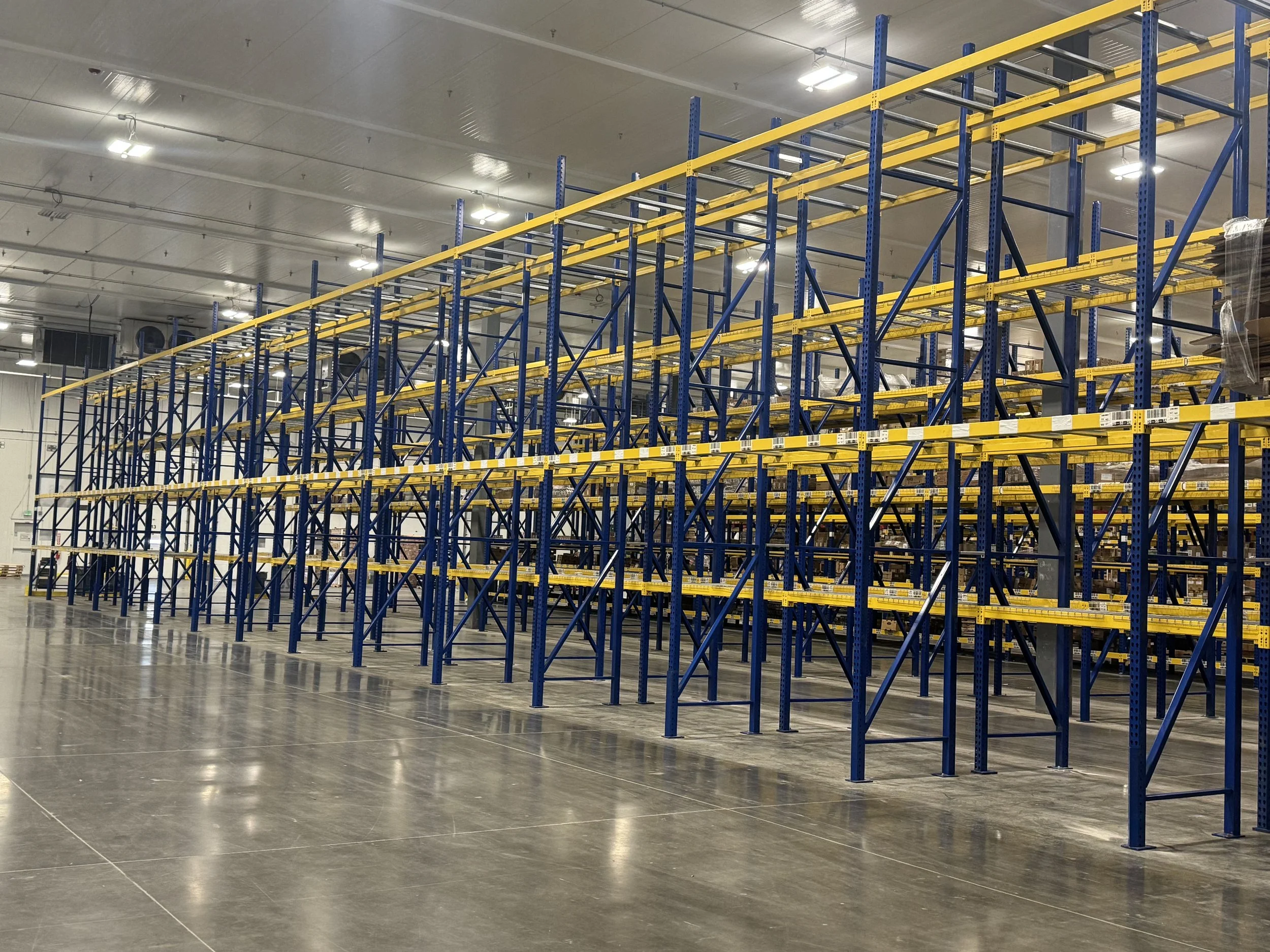 Empty warehouse with blue and yellow metal shelving units